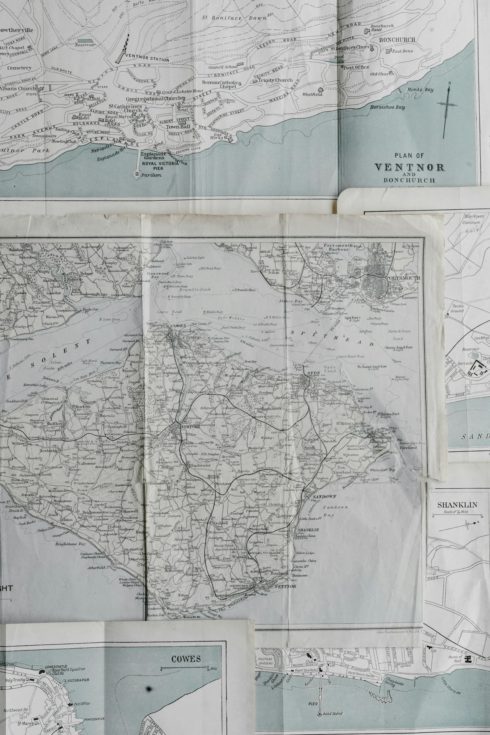 Two vintage maps, reflecting pale colours on a white background.