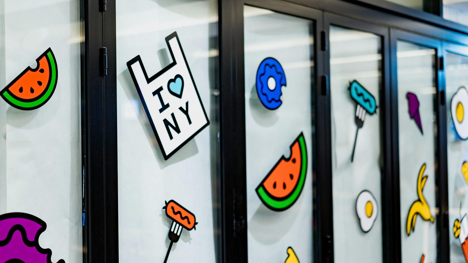A wall with colourful cartoon stickers pasted on it.