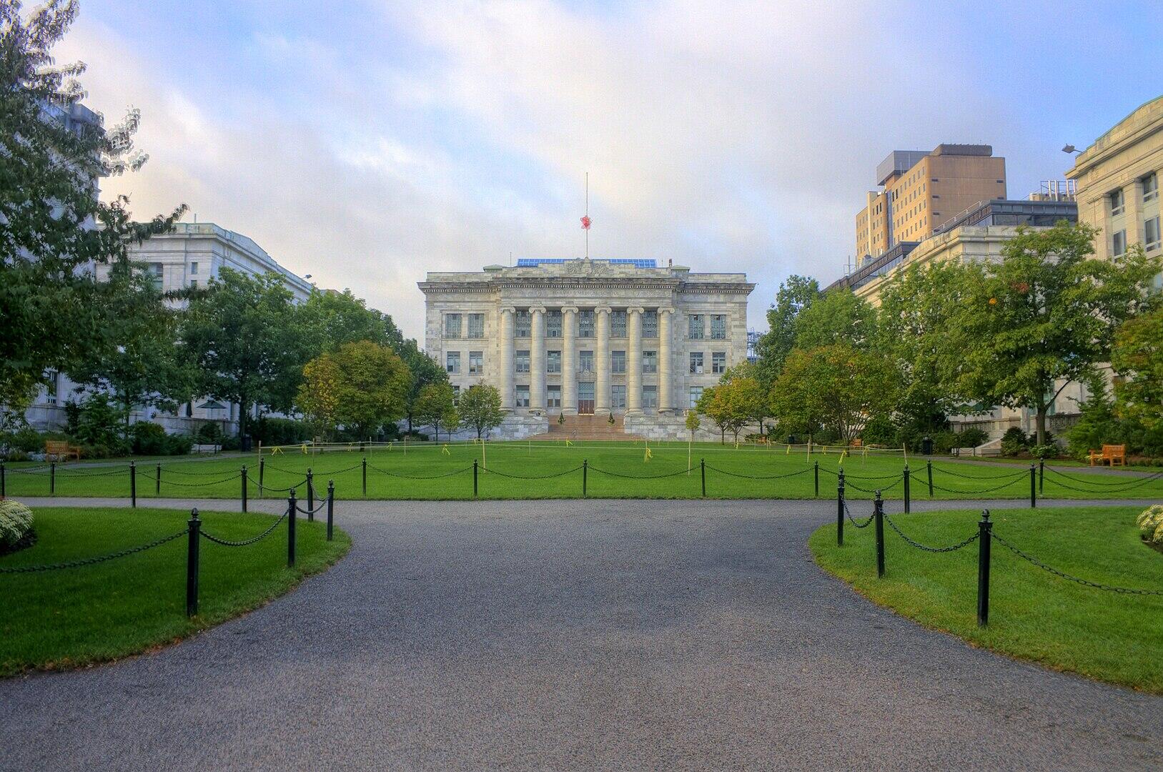 A large green space with a stone building in the background. 