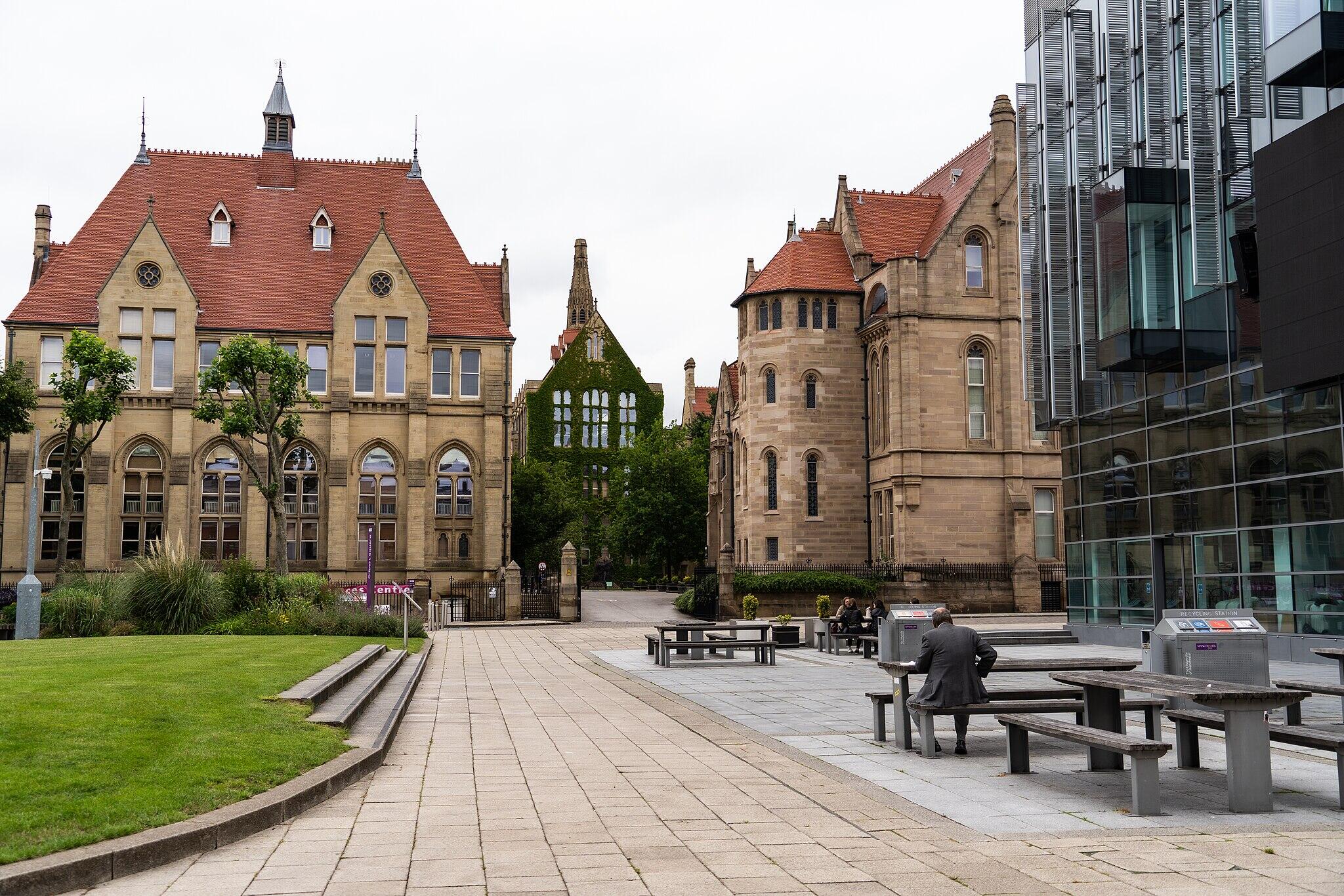 A pathway leading to stone buildings on a cloudy day.