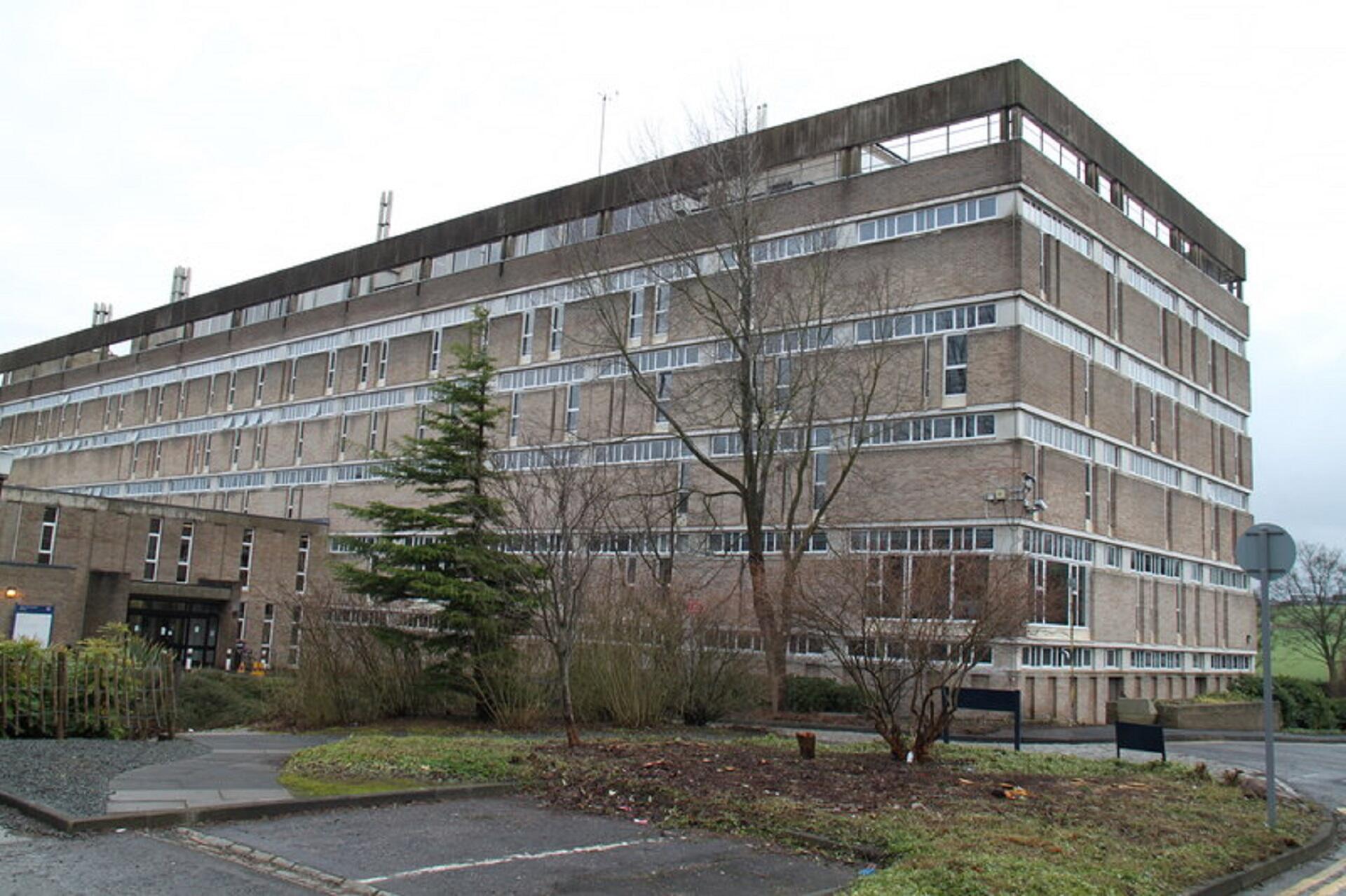 A tall stone building with many windows on a cloudy day. 