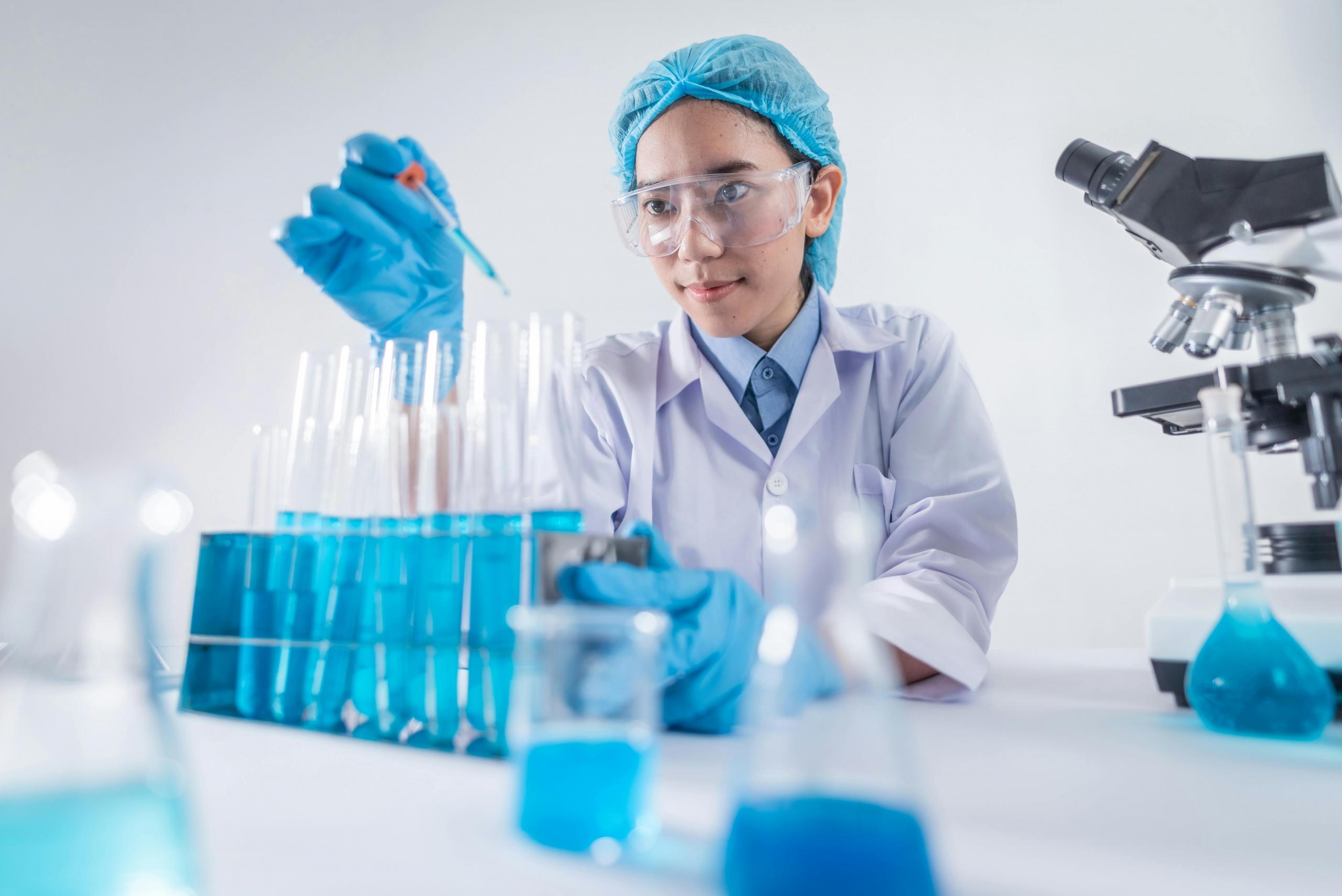 A female scientist carefully working with lab equipment in a well-lit laboratory environment.