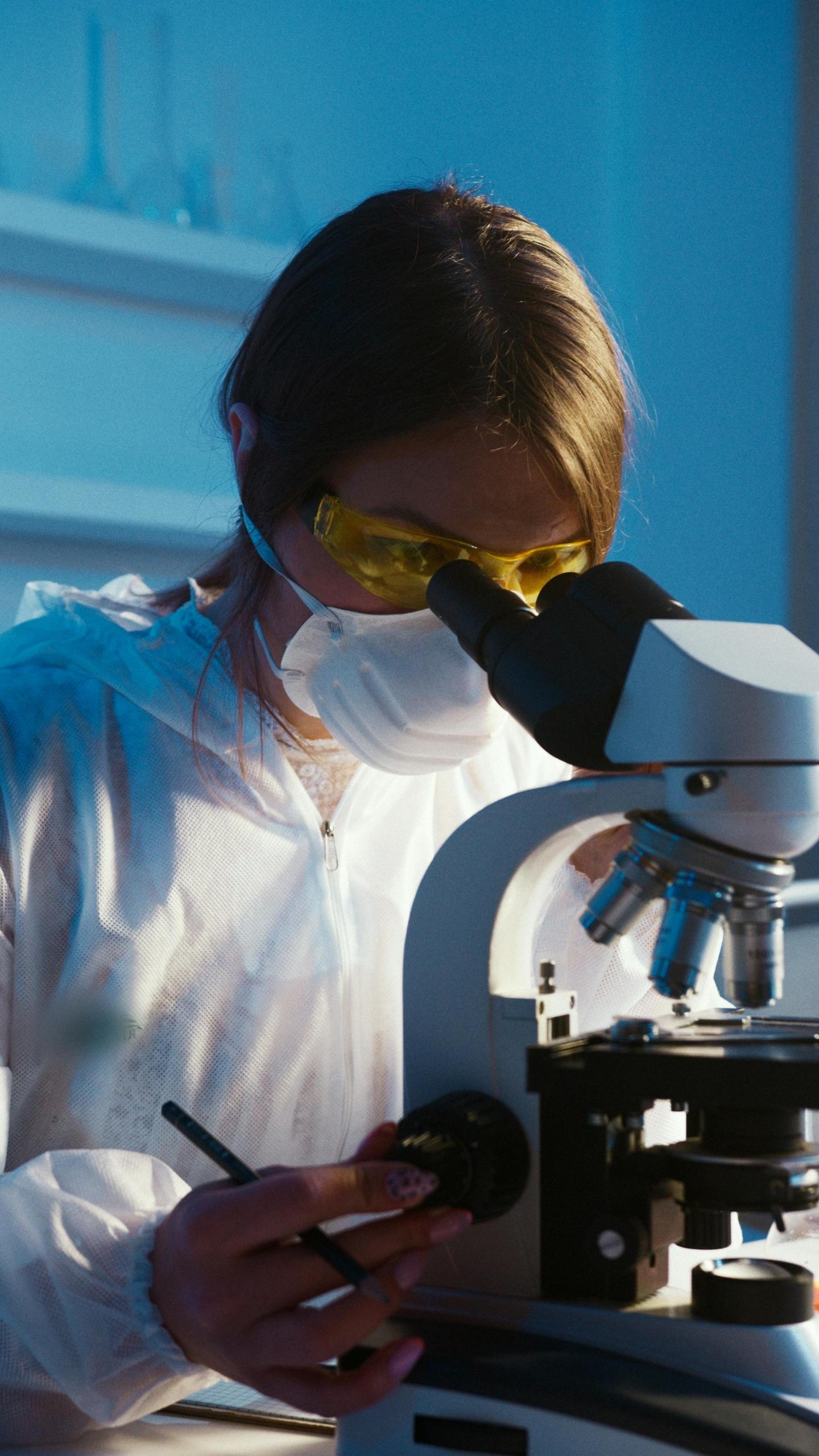 Photo of a woman looking through a microscope