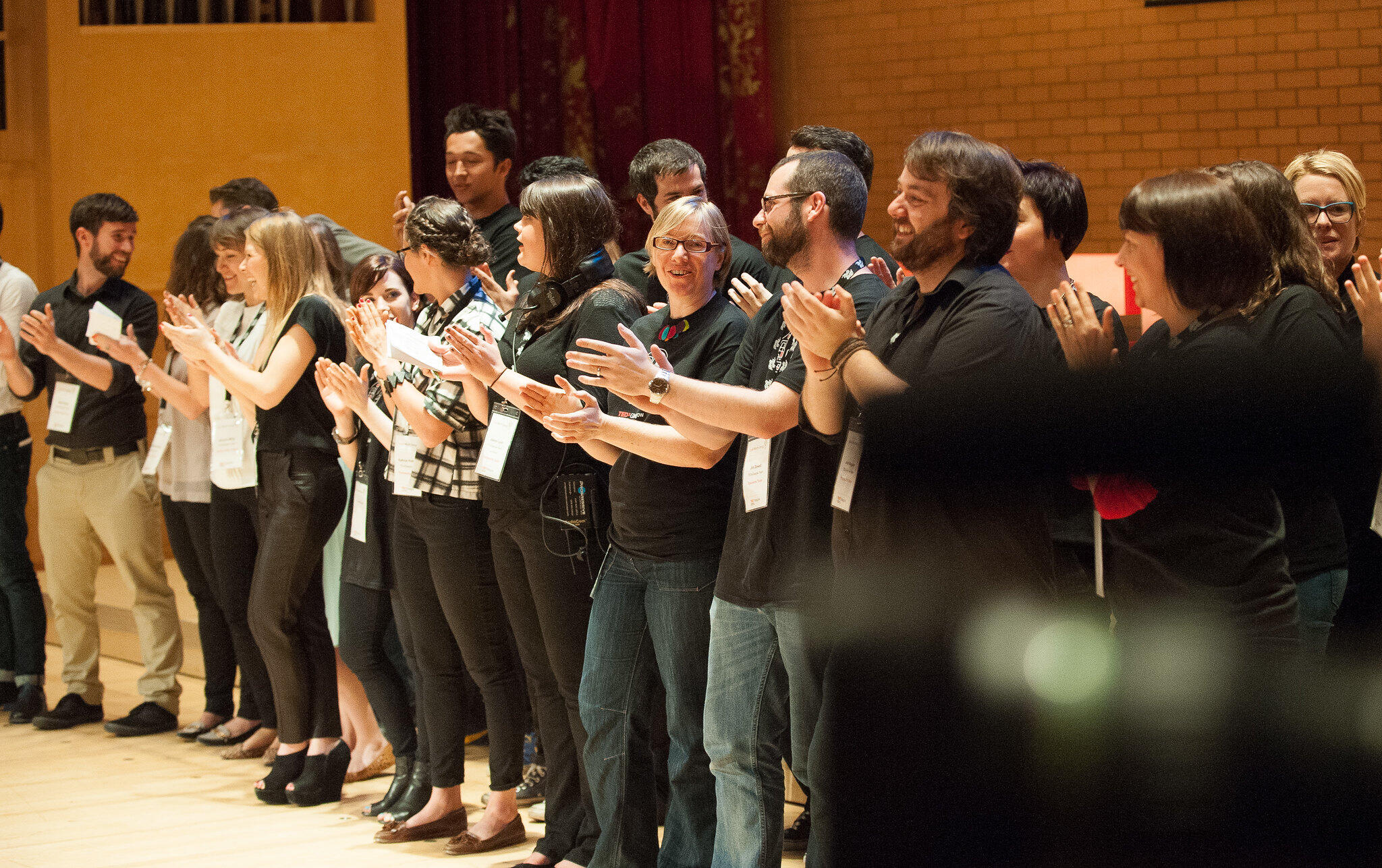 A crowd of people clap after watching an event at RCS