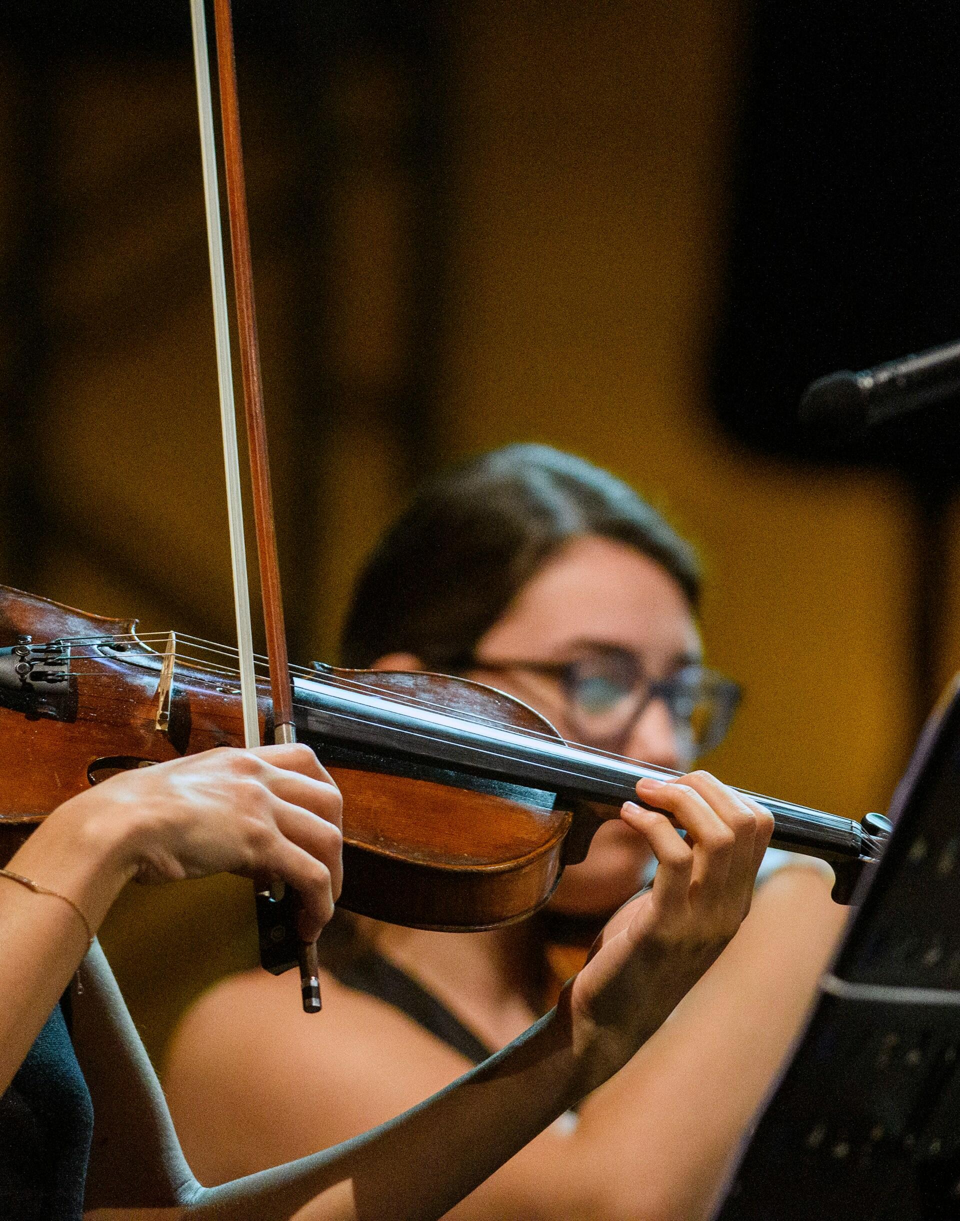 A violin being bowed as part of an orchestra performance.