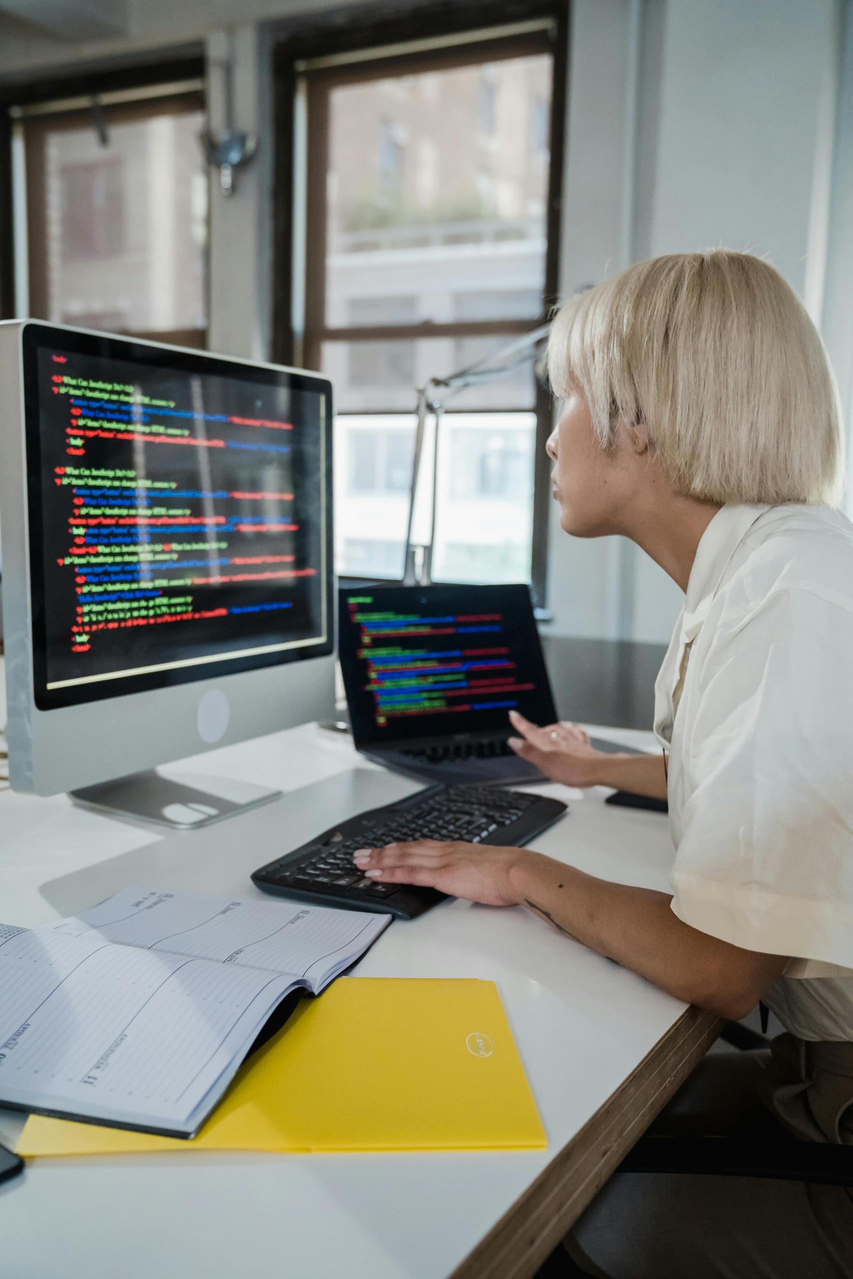 Woman looking at a screen with colorful programming code