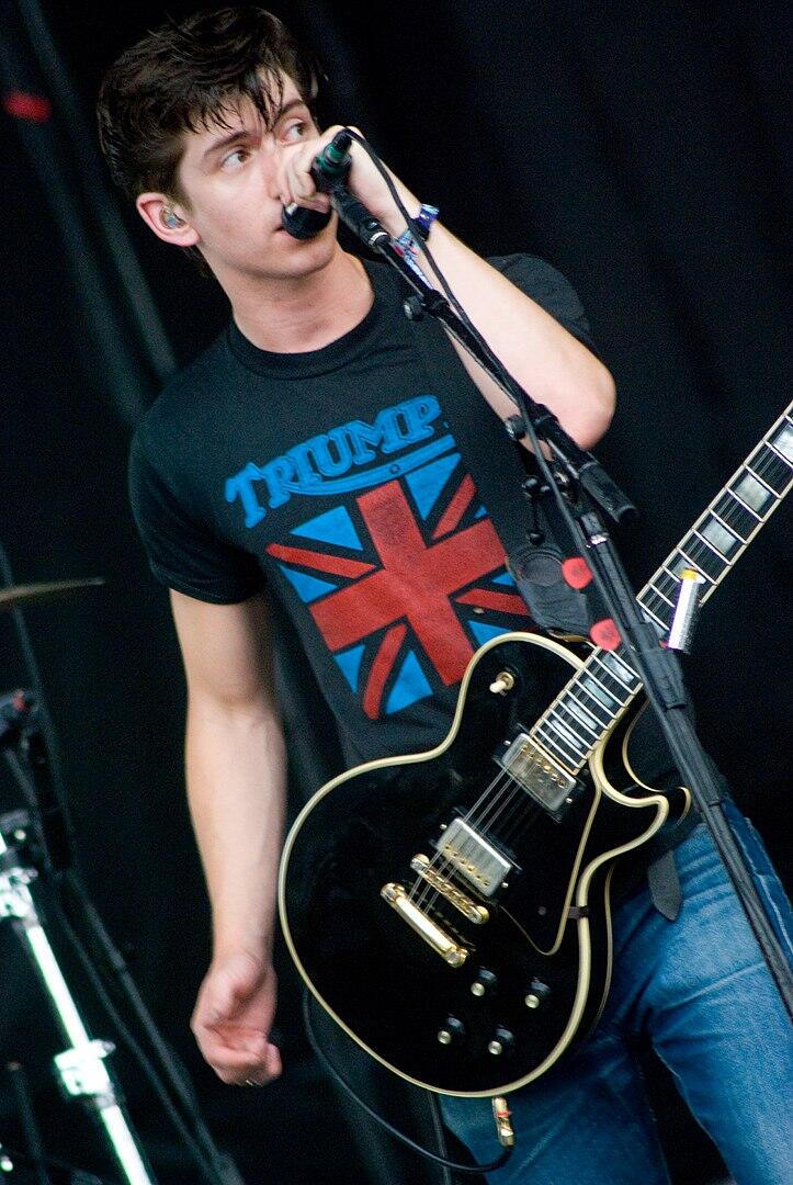 Alex Turner with guitar on stage with the Arctic Monkeys