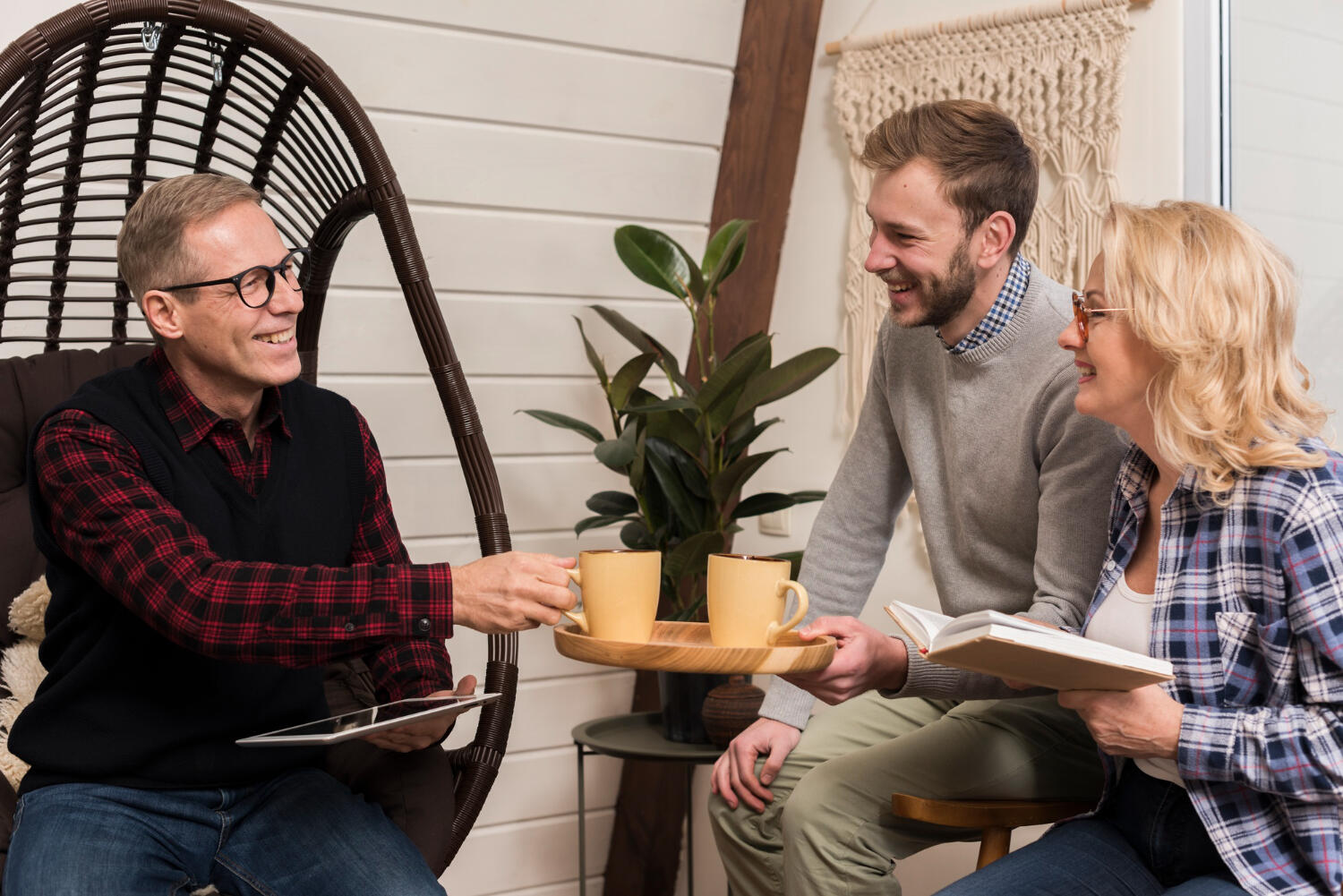 a guest talking to a couple at home while having tea.