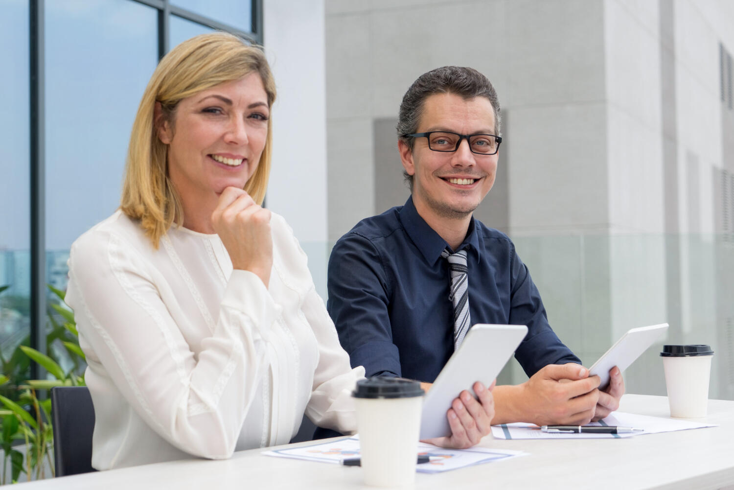a male and female sitting and interviewing someone.