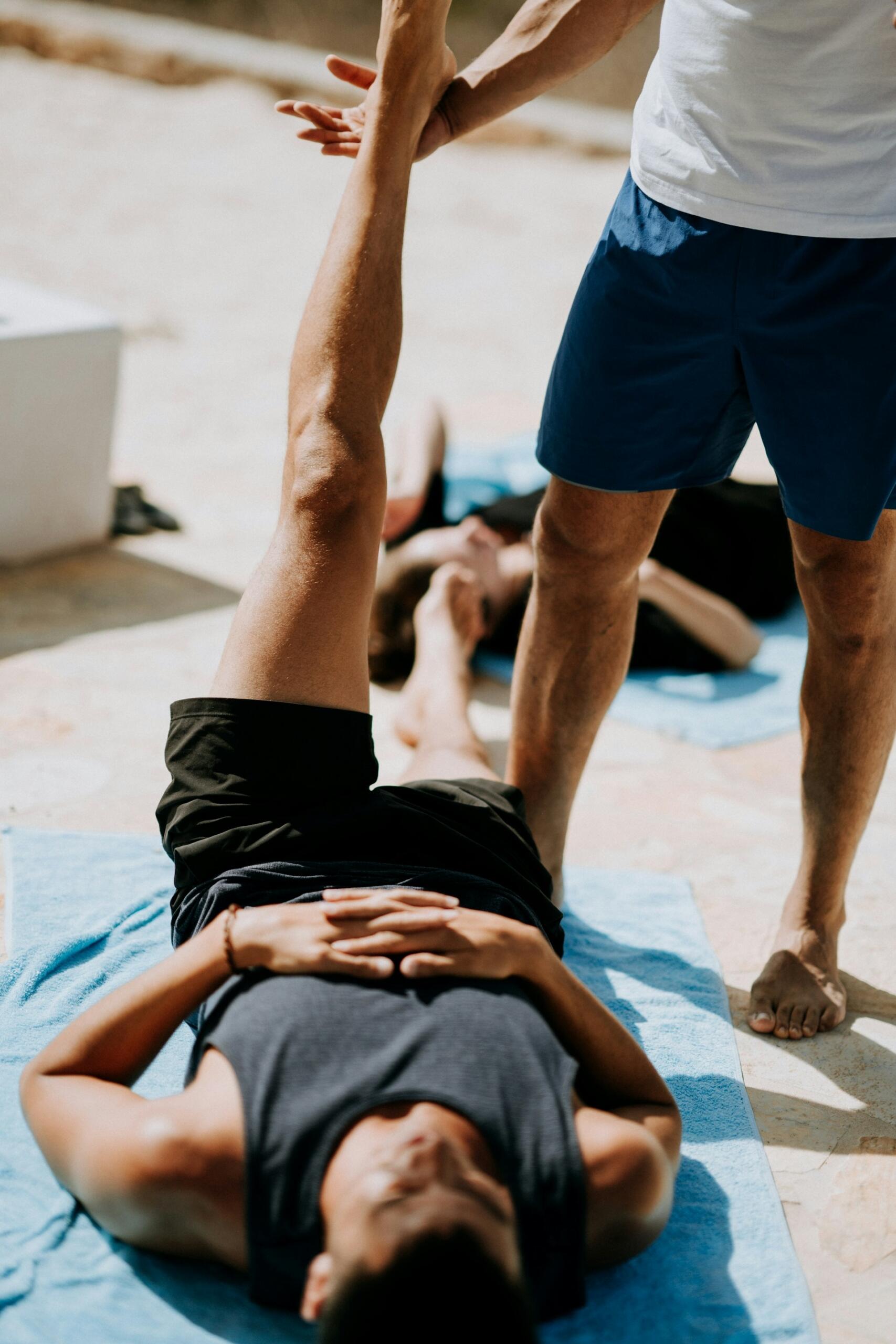 a personal trainer helping a man with a leg warm up