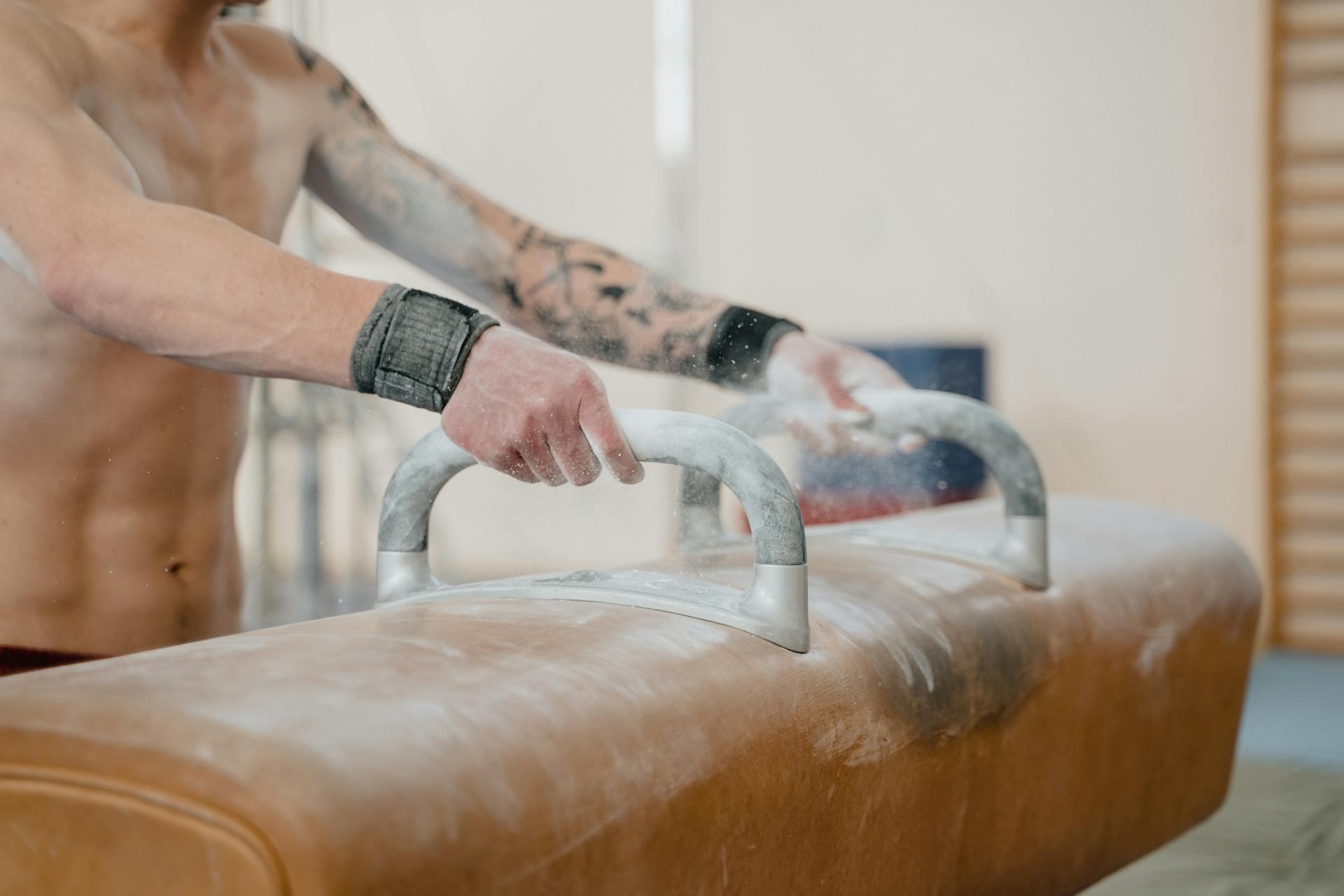 Hands on a pommel horse.