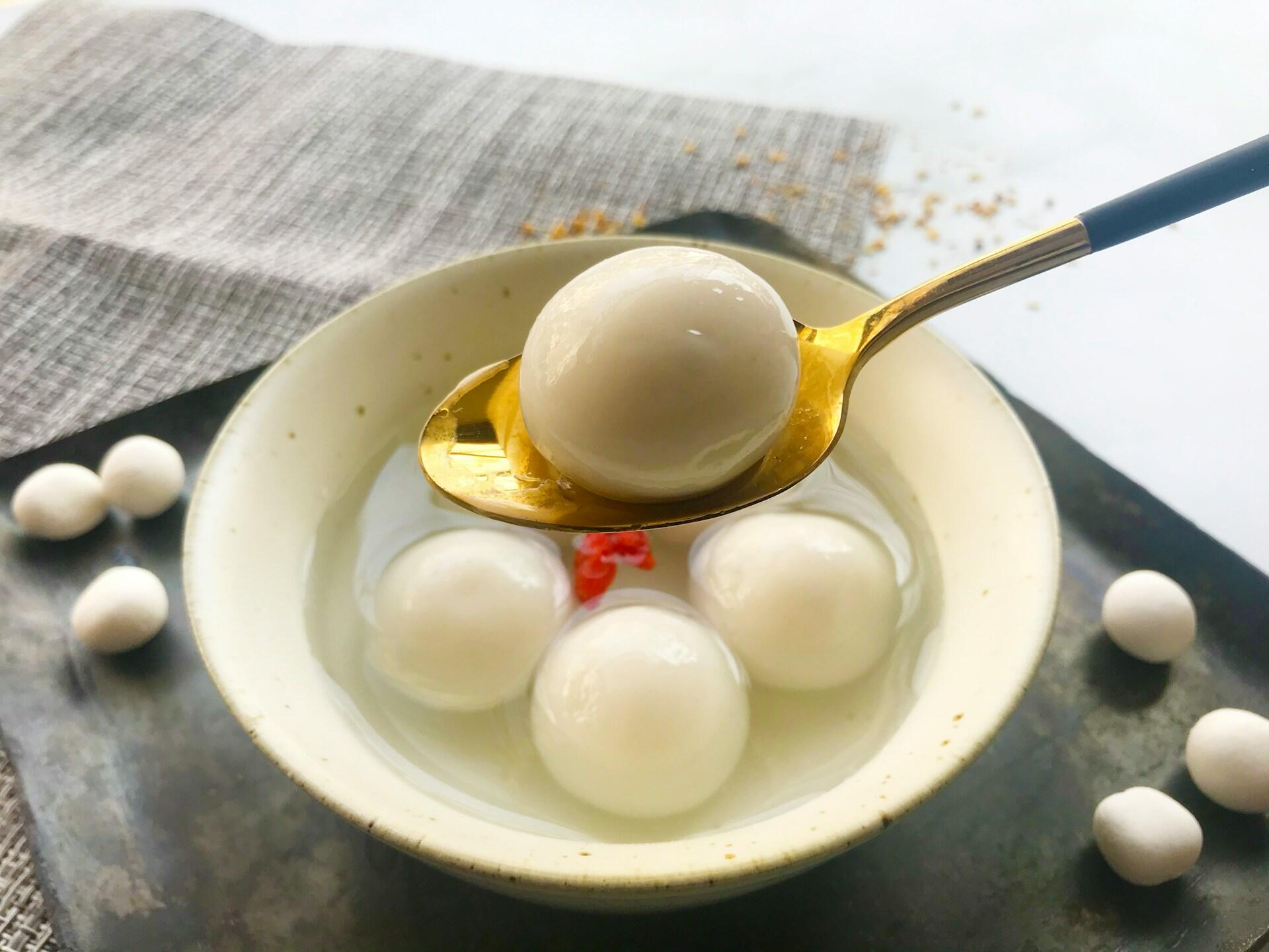 White rice ball on a golden spoon.