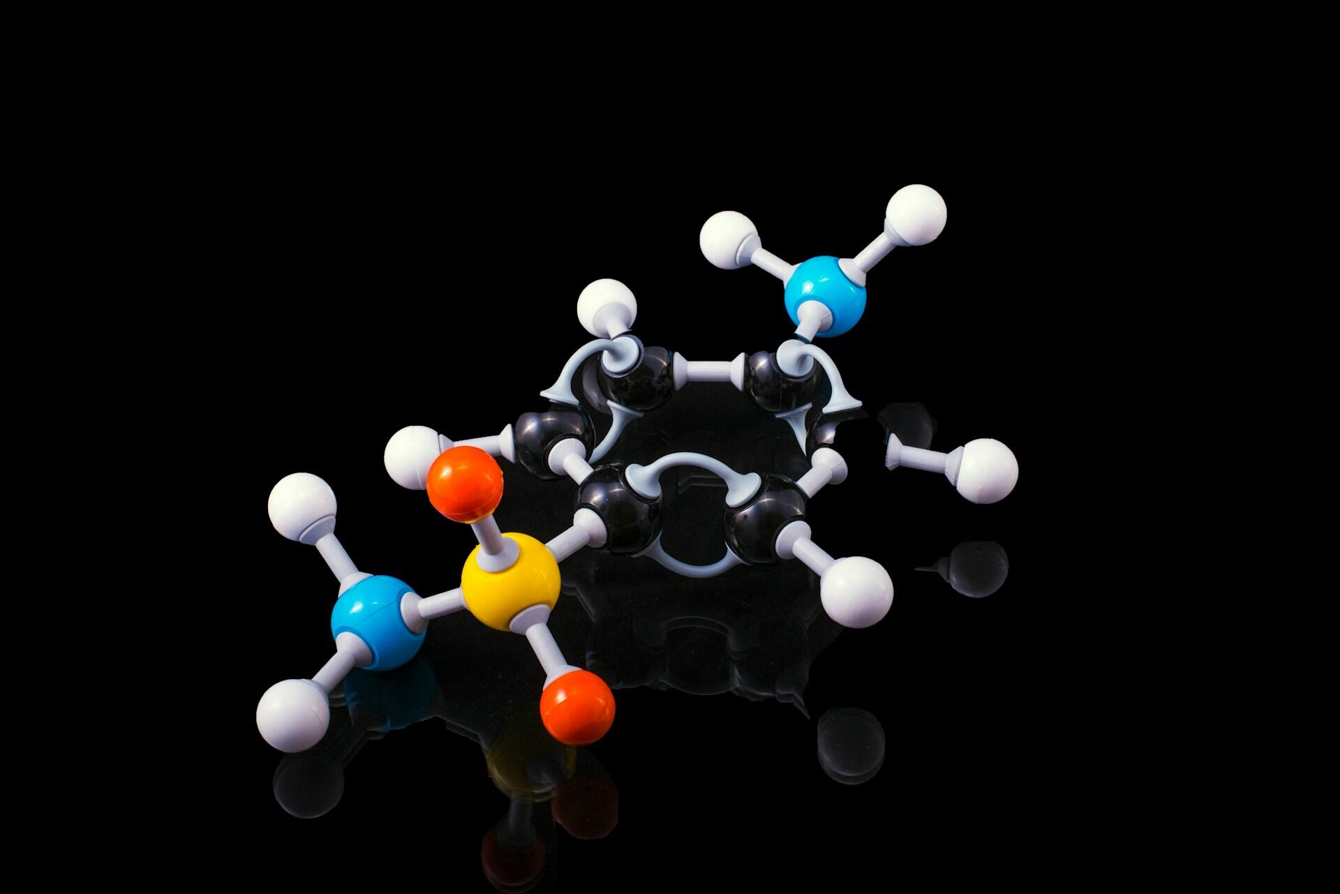 A colourful chemical molecule against a black background. 