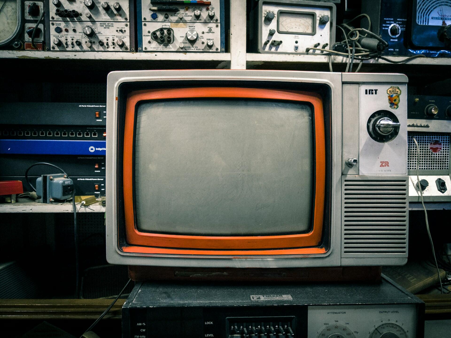An old portable TV with an orange rim around the screen. 