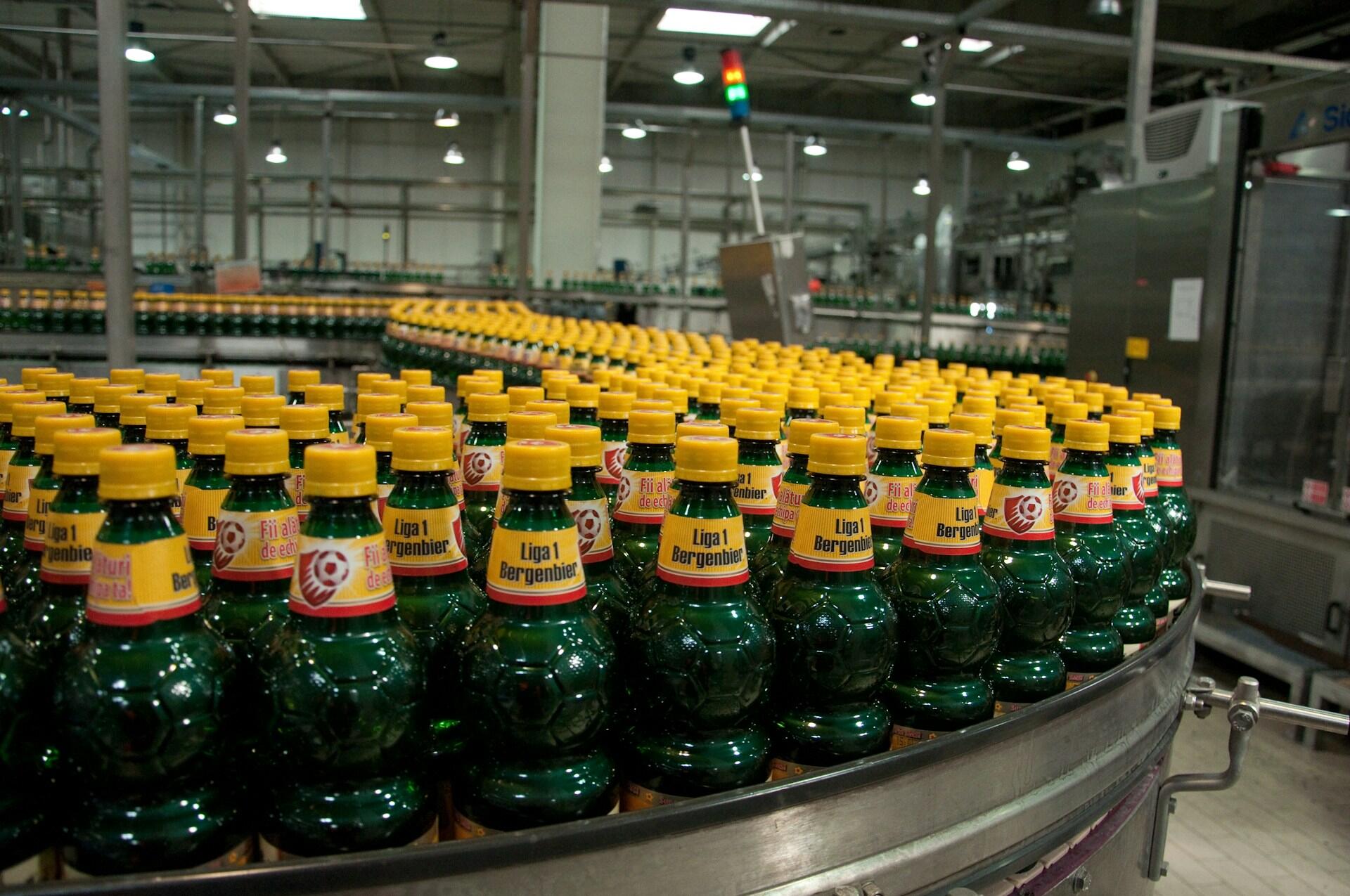 Bottle with yellow labels on a conveyor line. 