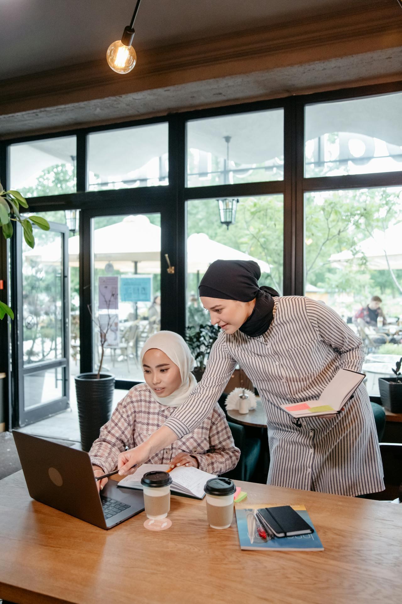 Women using a laptop while discussing someting together