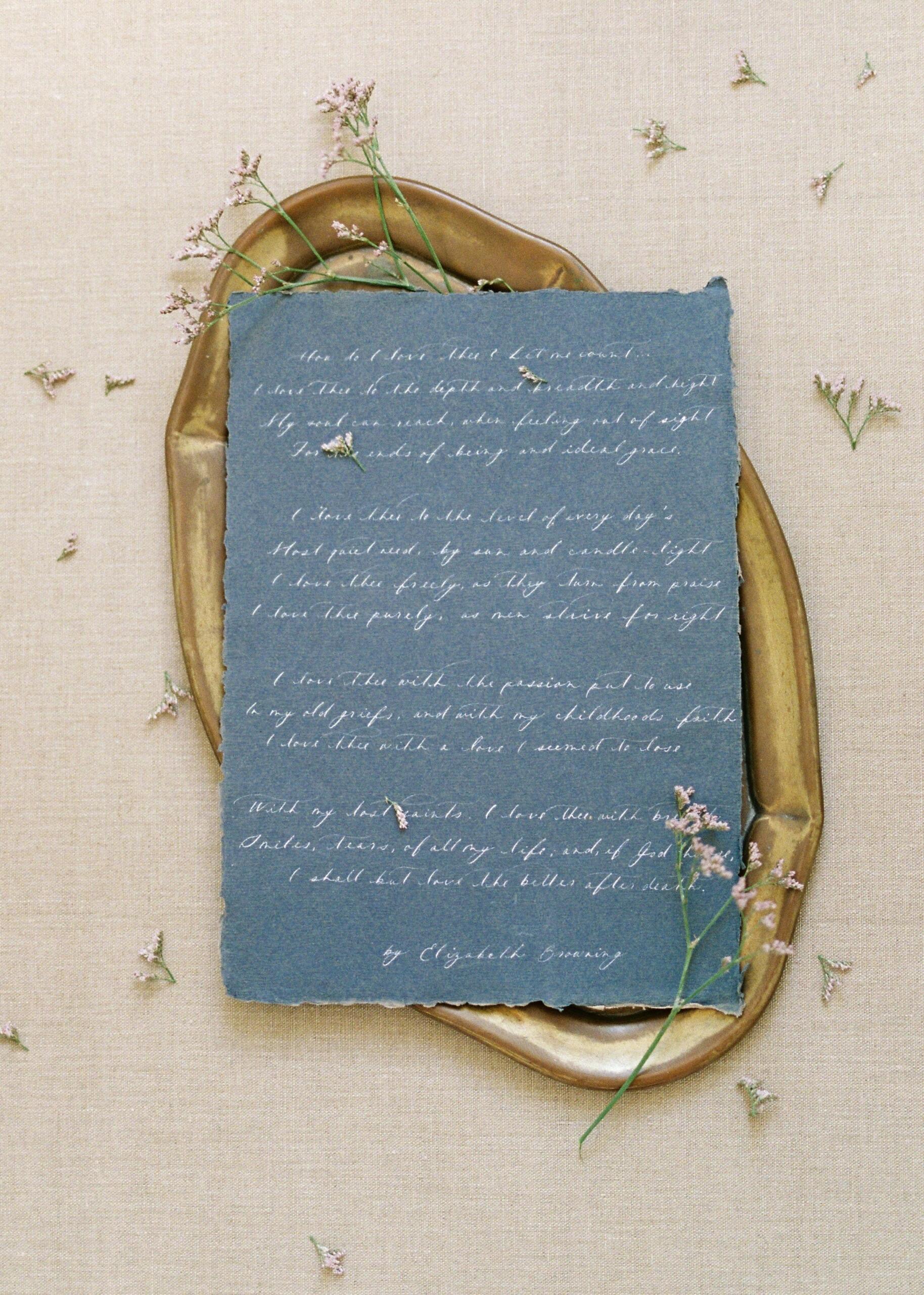 A blue sheet of paper with handwriting placed on a brown oval tray.