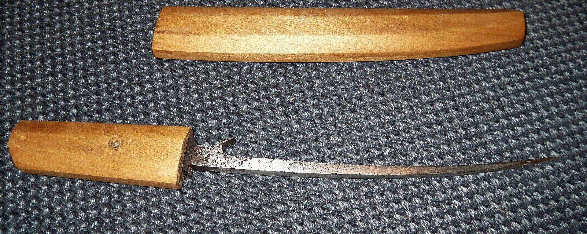 A knife with a wooden handle and sheath. 