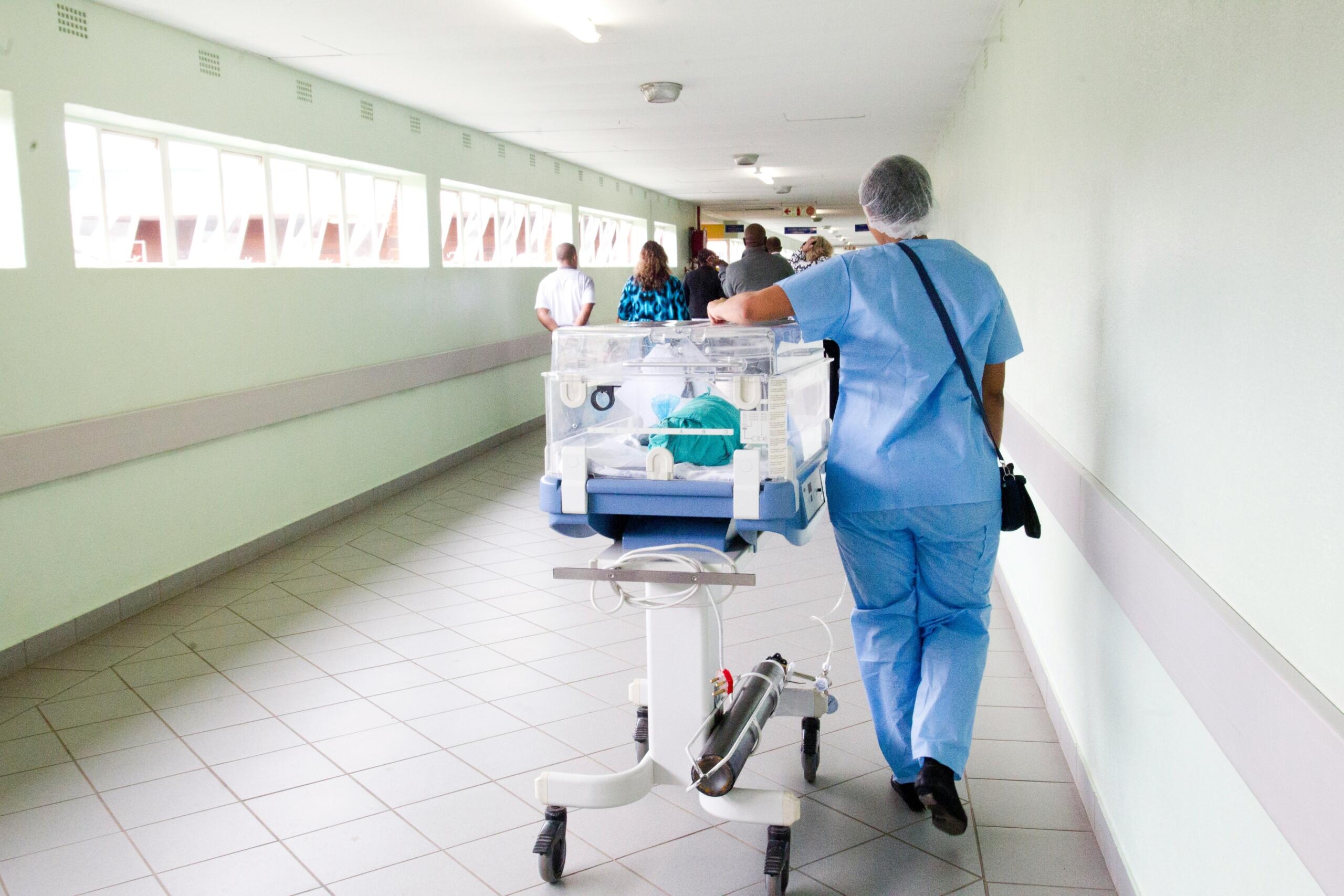 nurse walking into an ER room with medical equipment