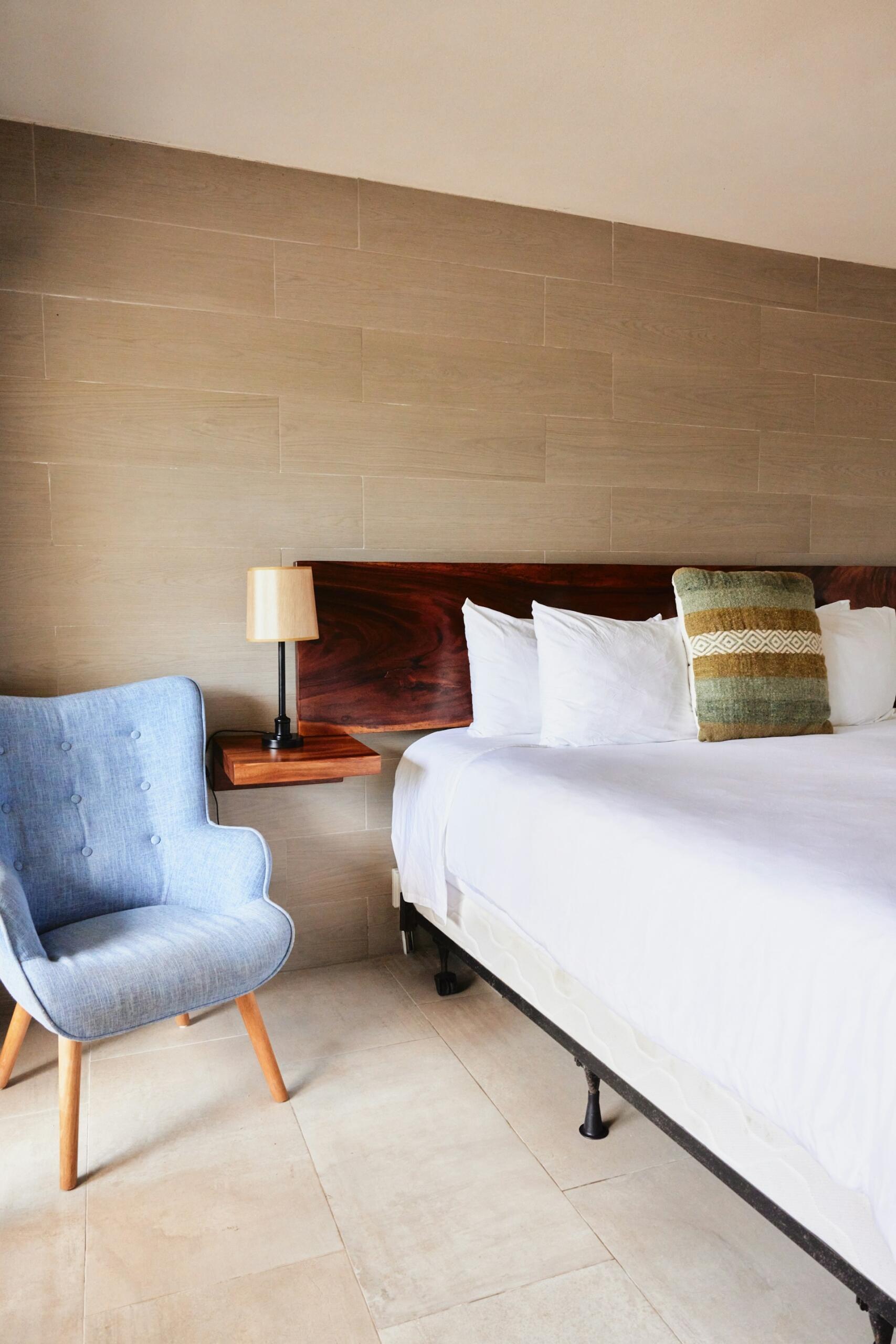 A hotel room featuring a blue chair.
