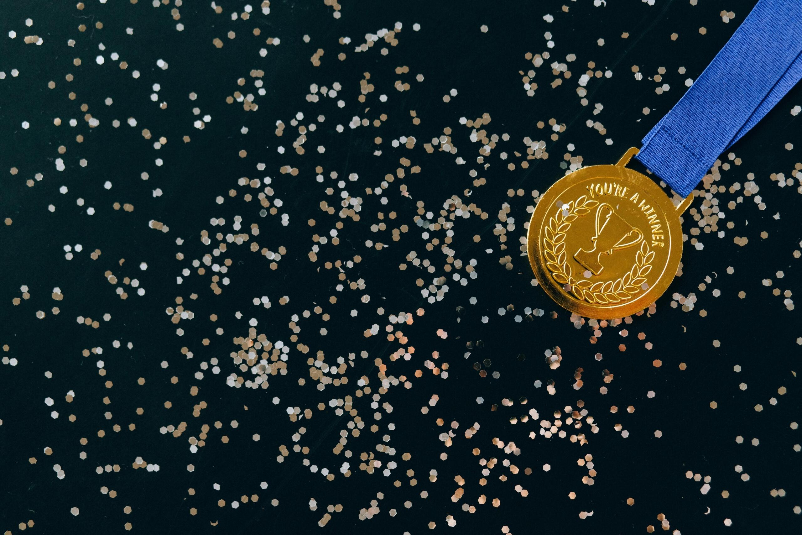 Close-up shot of a gold medal placed on a black surface.