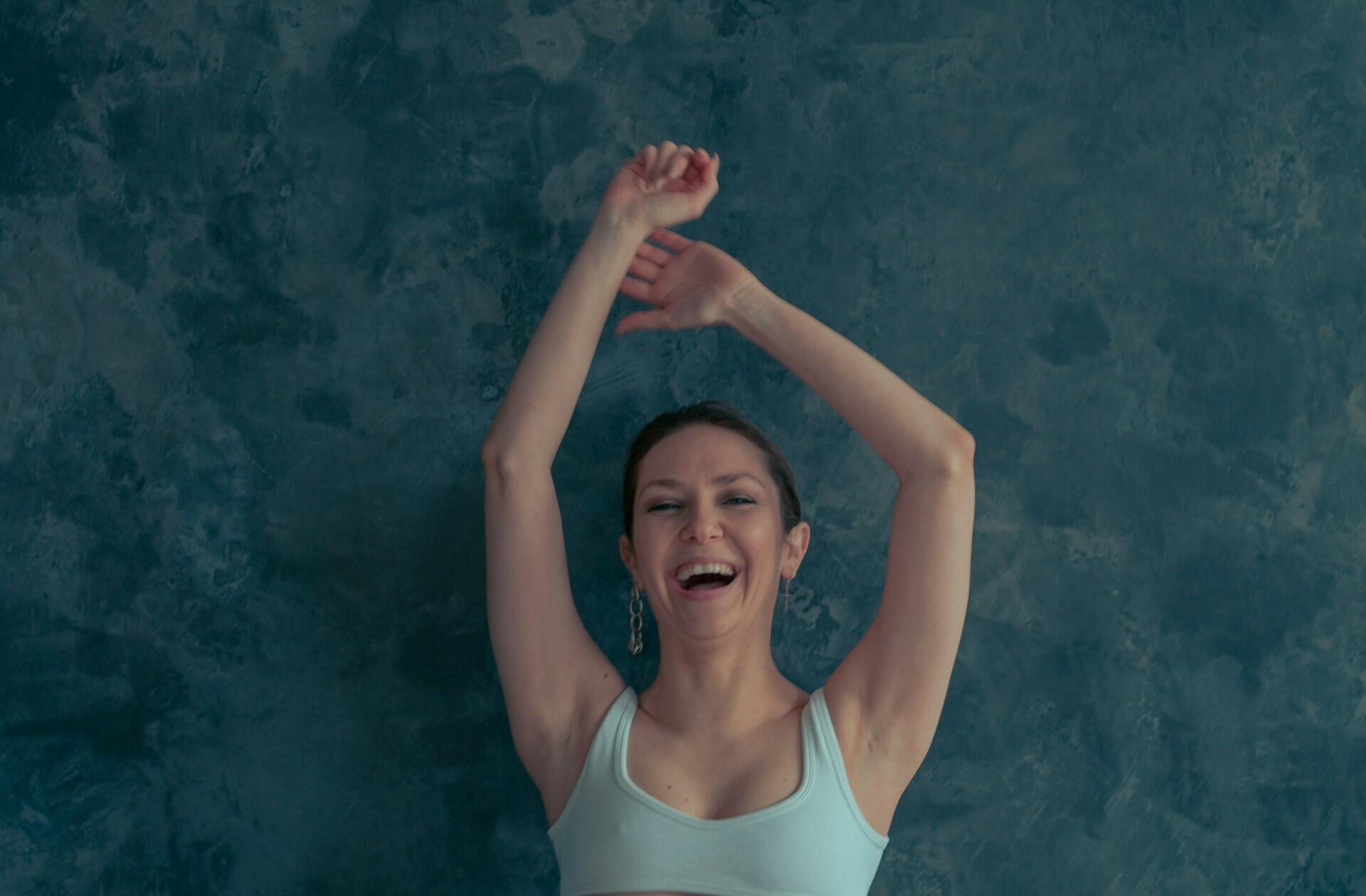 woman holding her hands up over her head in a dance position