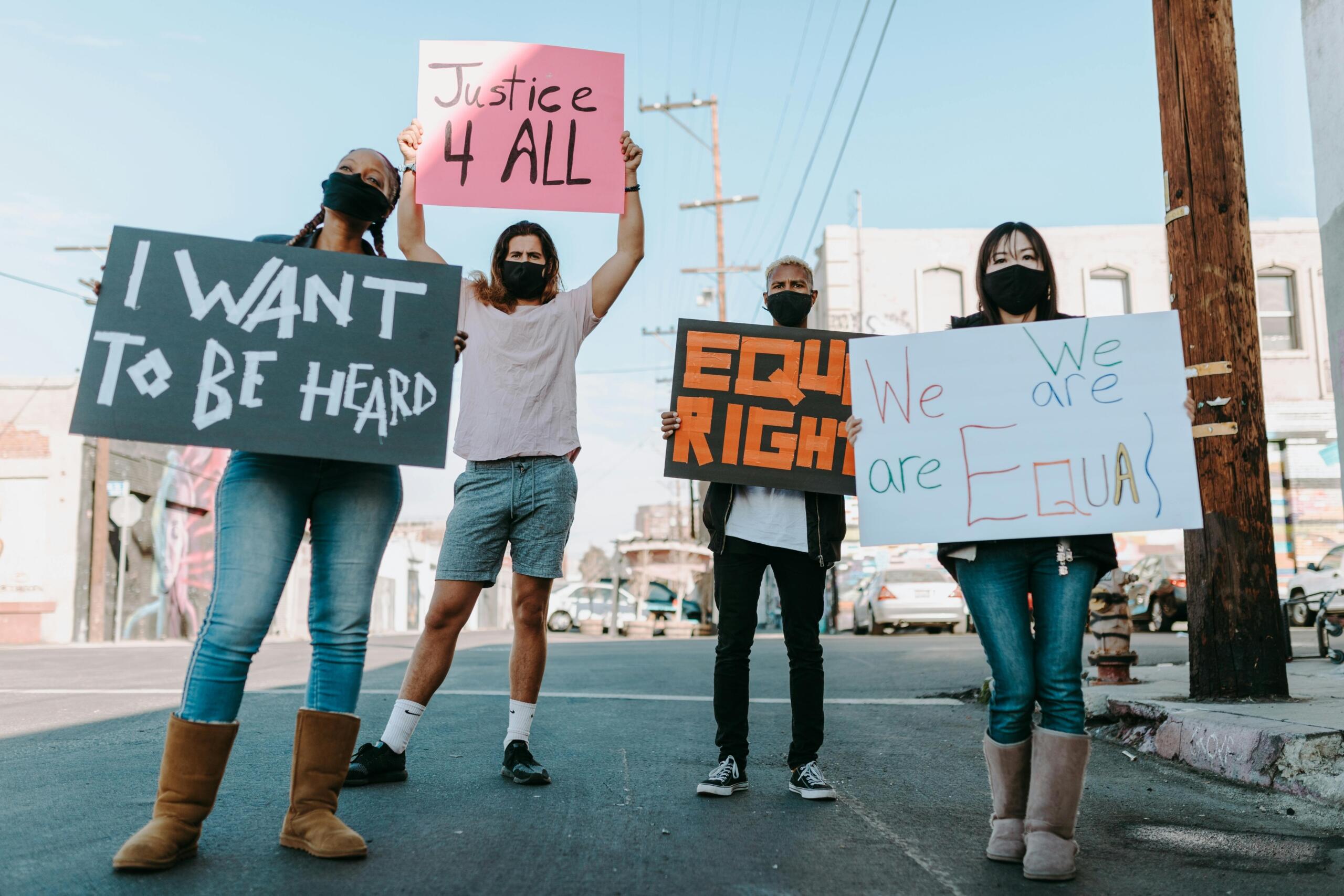 A group of people standing on the street holding placards during a demonstration.