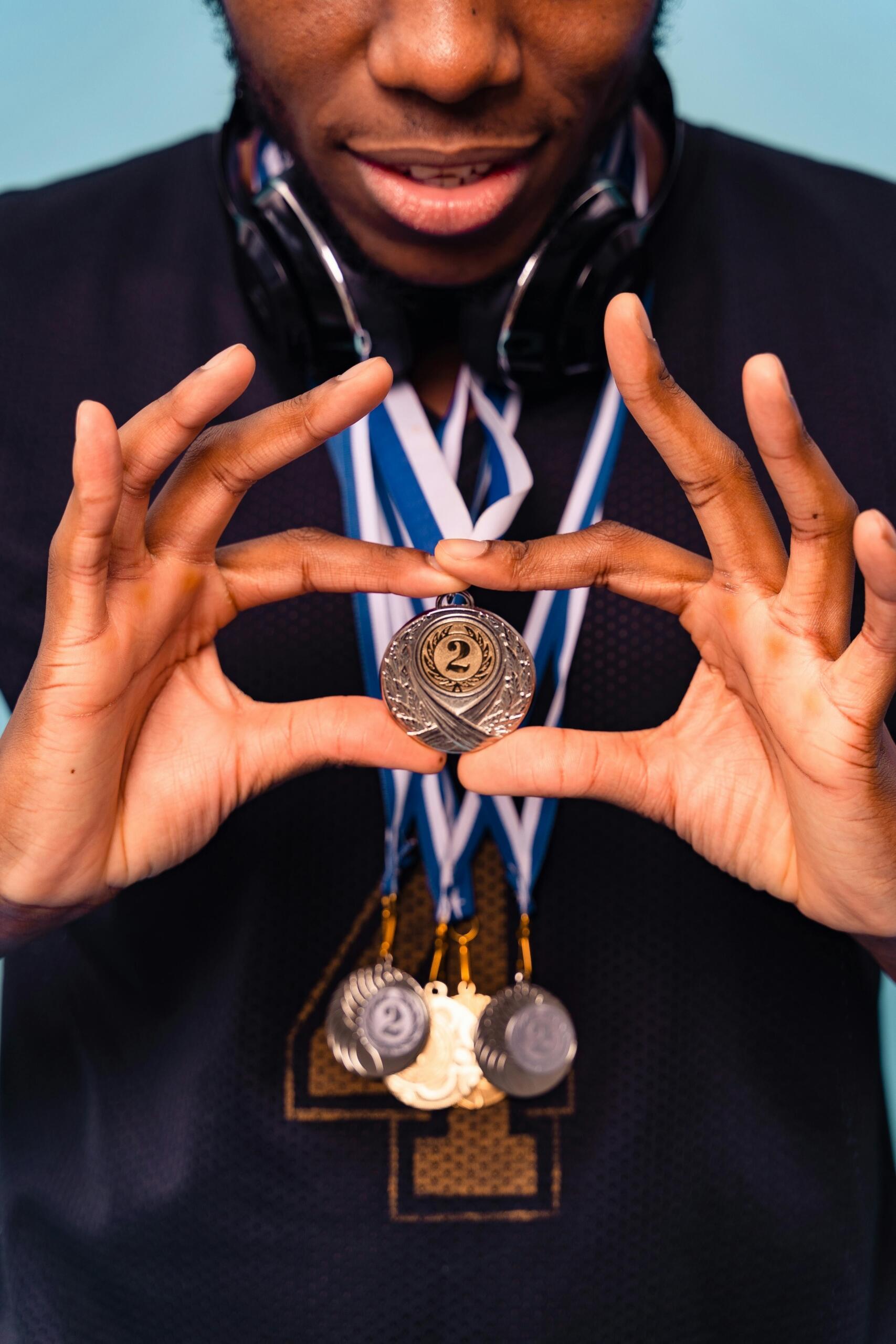 Close-up of hands holding a medal with a ribbon.