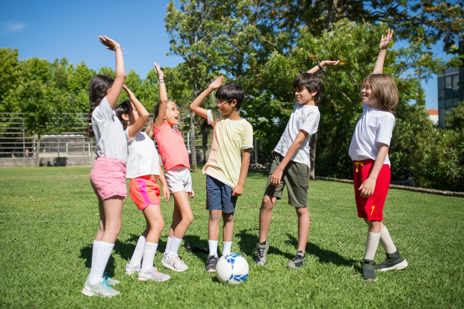 Kids playing football, high fiving