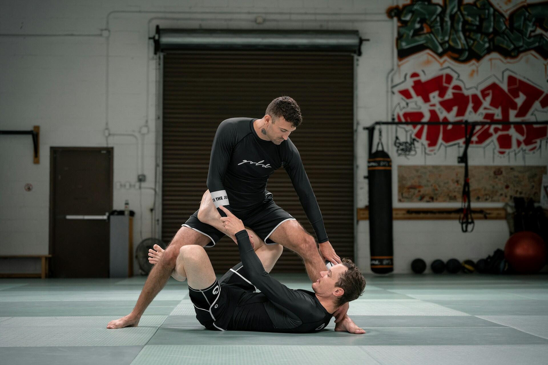 Two people doing jiu jitsu.