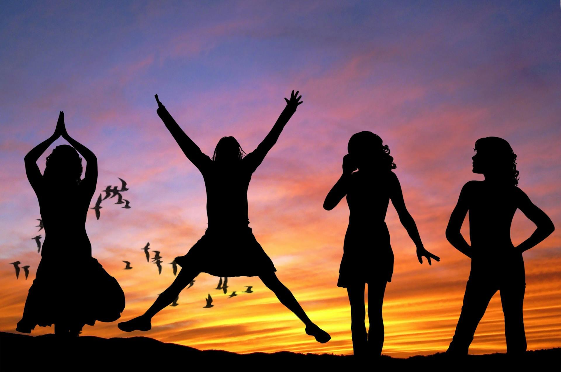 Kids jumping with sunset in background 