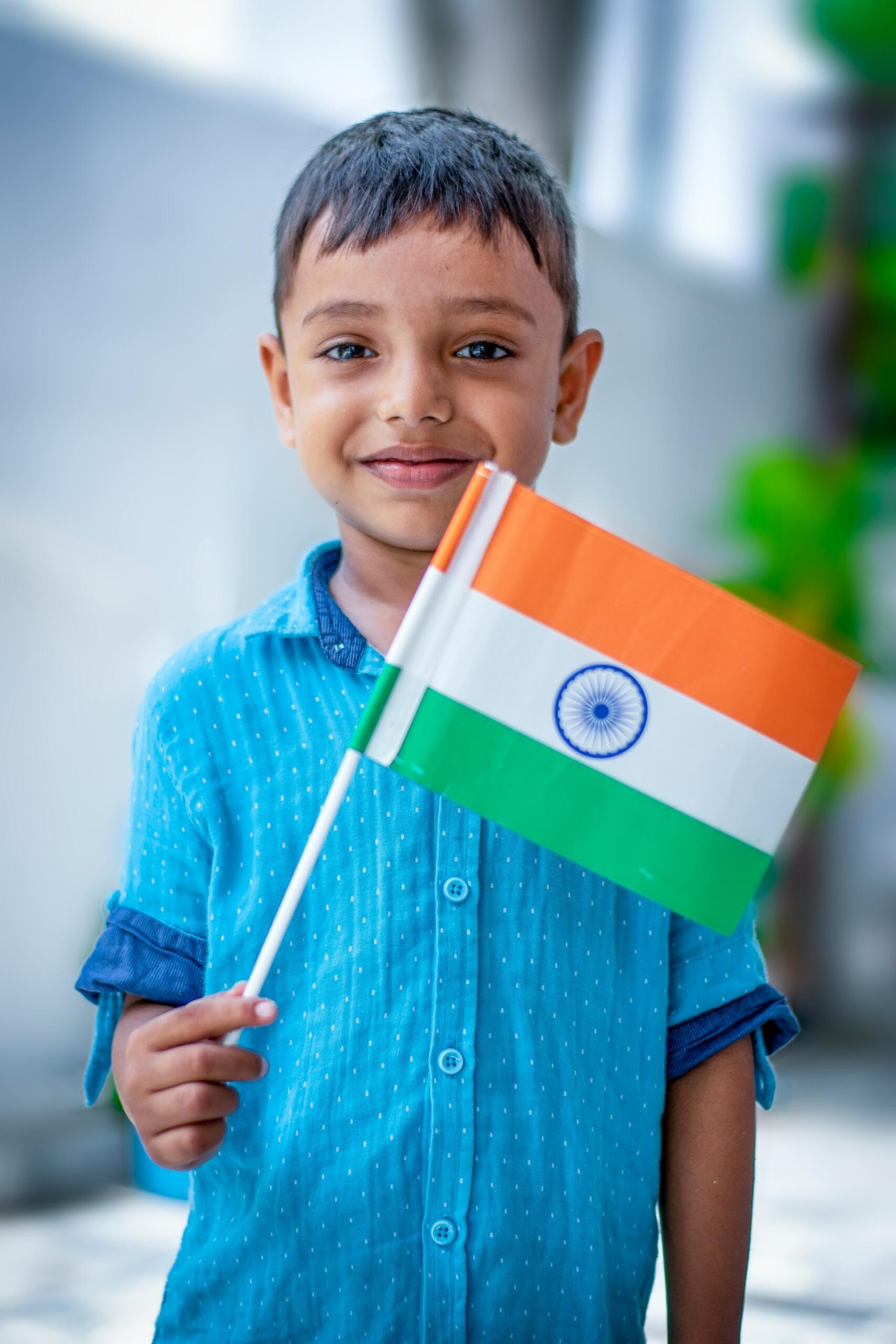 A child in a blue shirt holding a flag. 