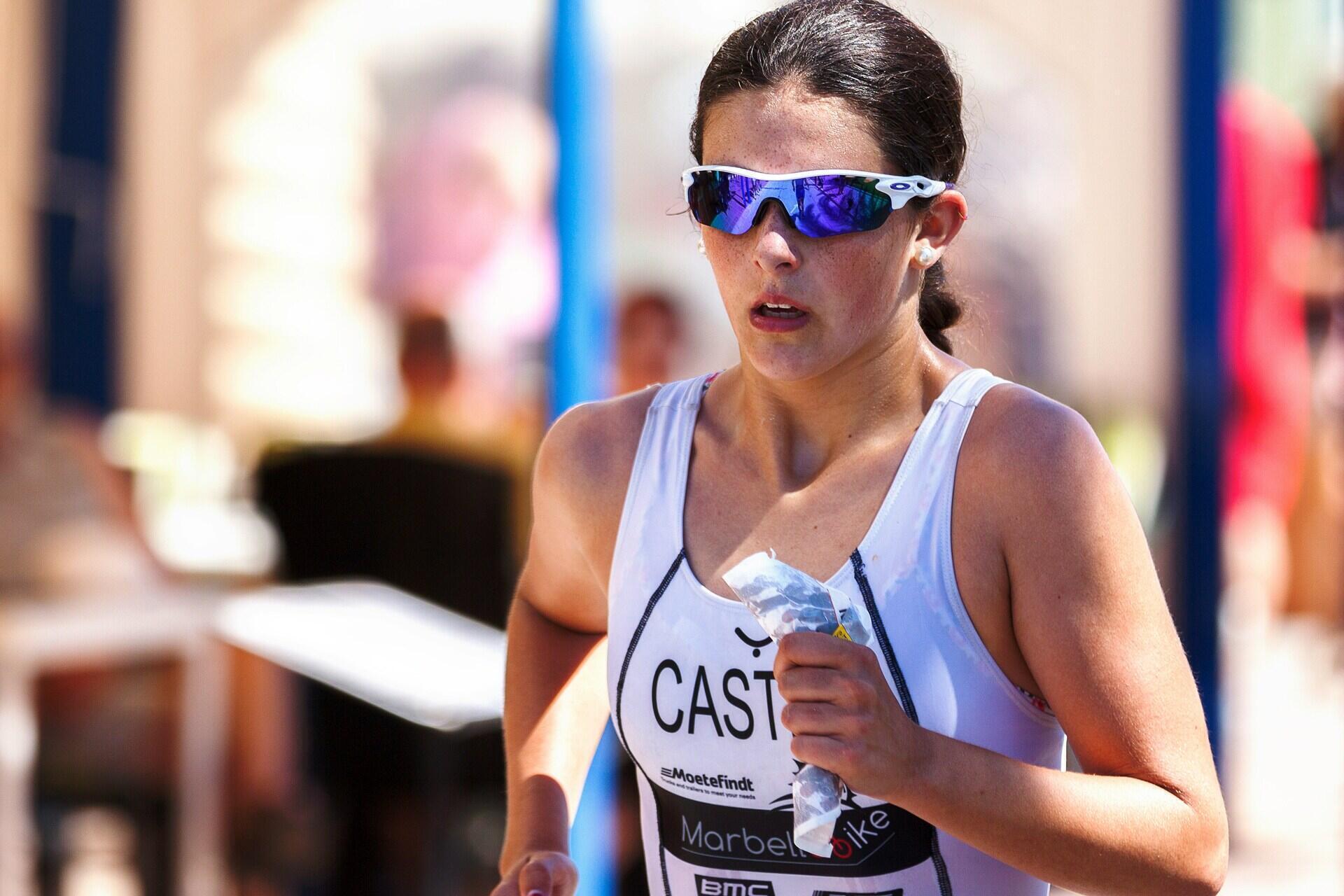 a woman running dressed in sports kit and sports sunglasses