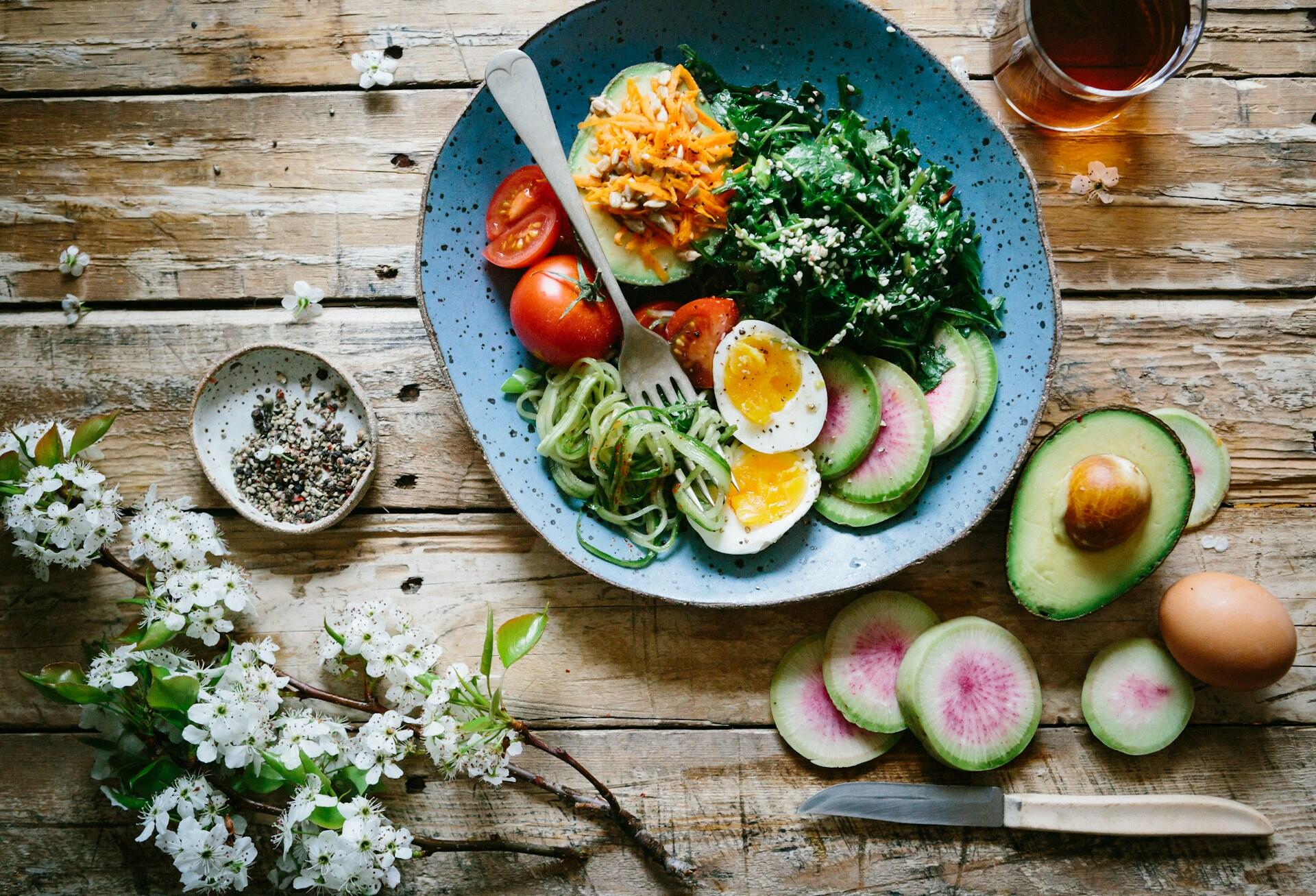 a table set with a salad, poached eggs and a cup of tea