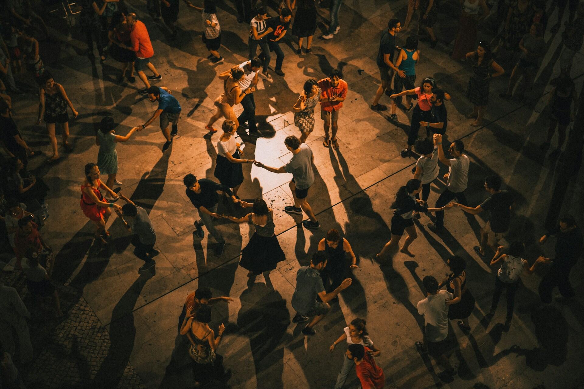 Groups of people dancing together in a crowded indoor space