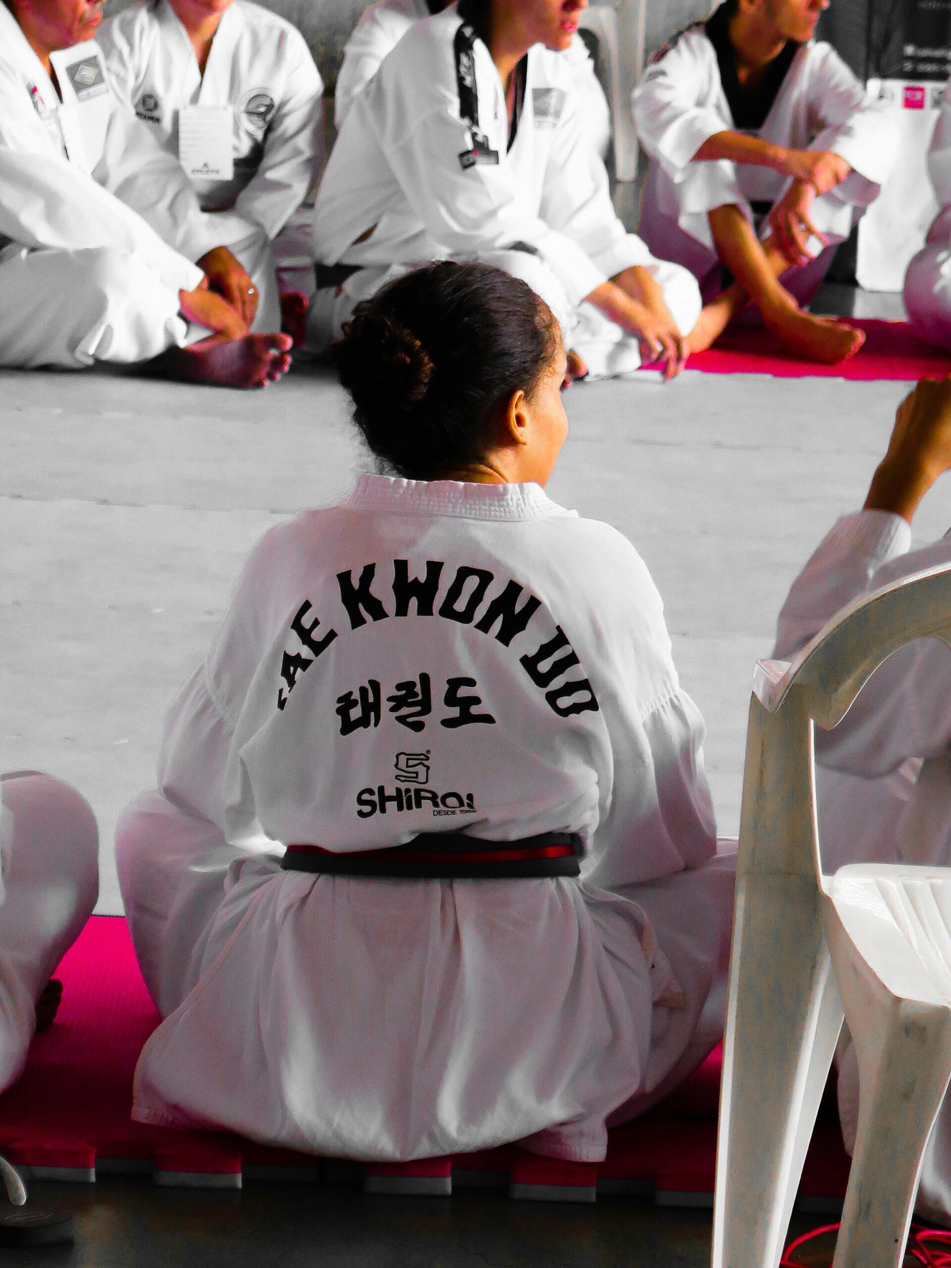 A taekwondo student sitting on the floor.