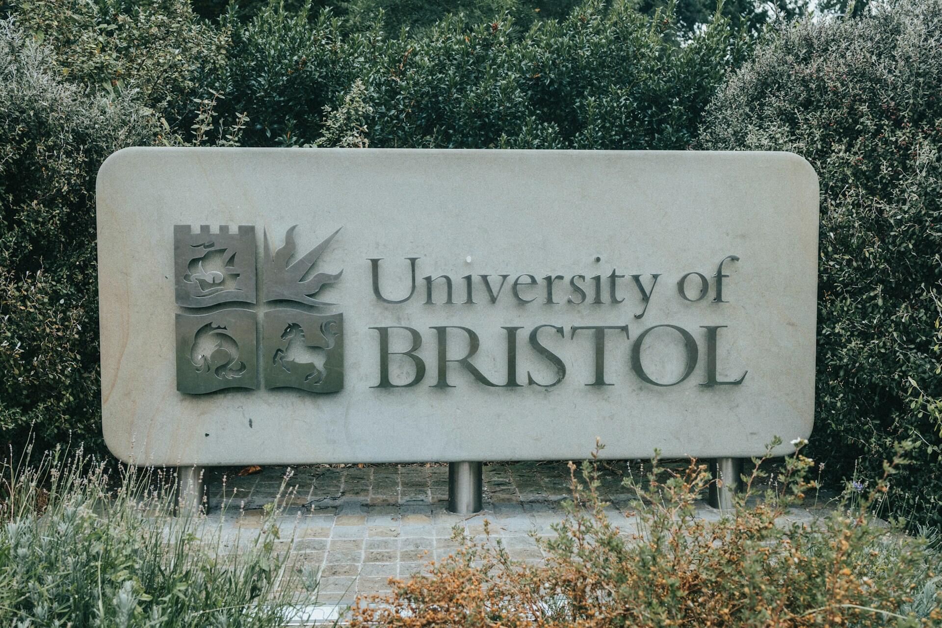 A grey sign with darker writing on it. 