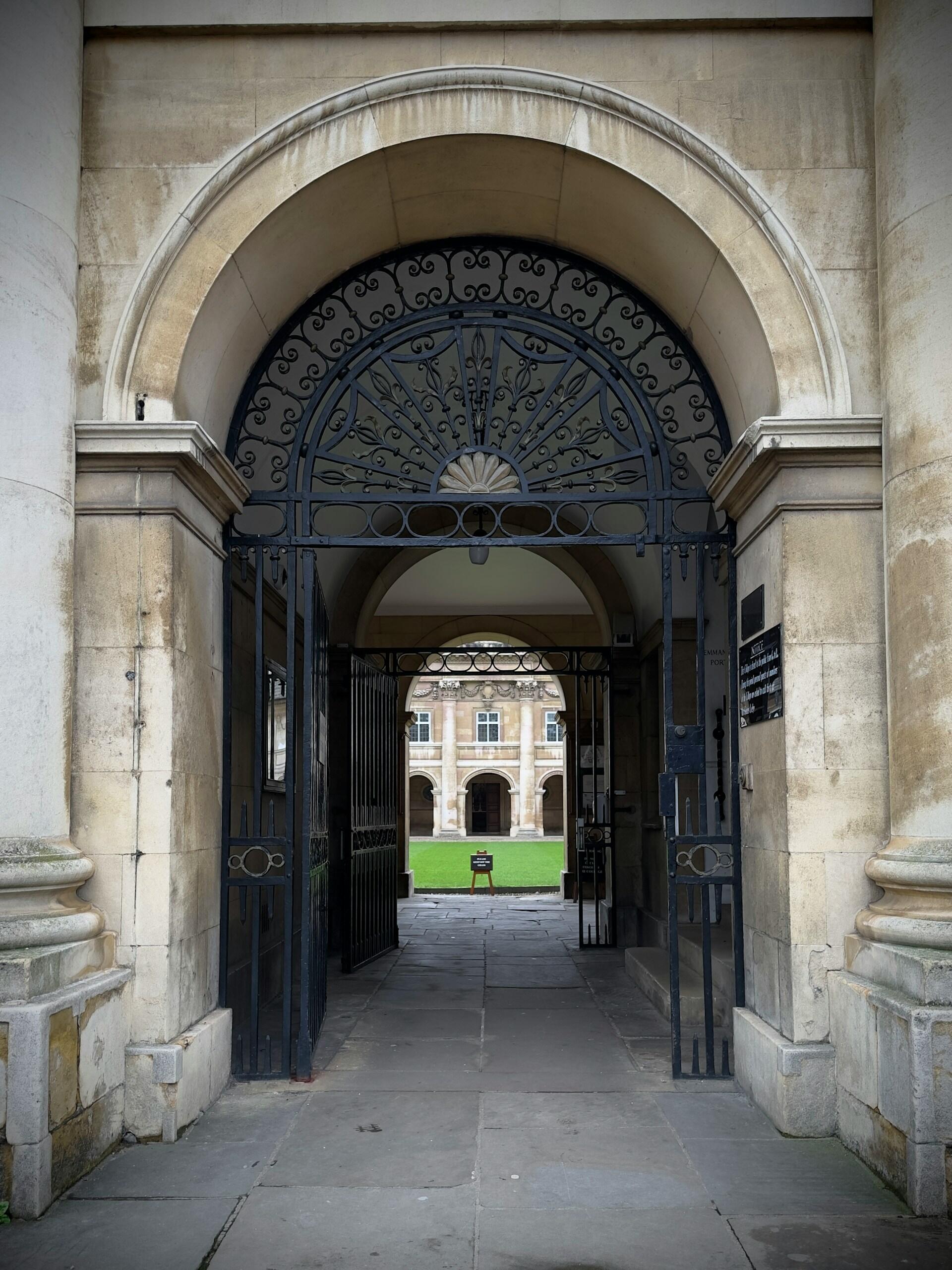 A stone archway with a black iron gate. 