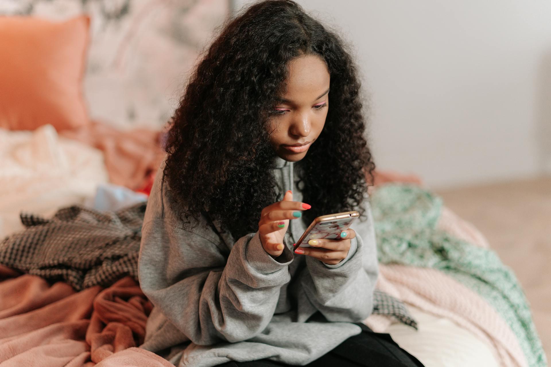 Child looking at phone in bedroom