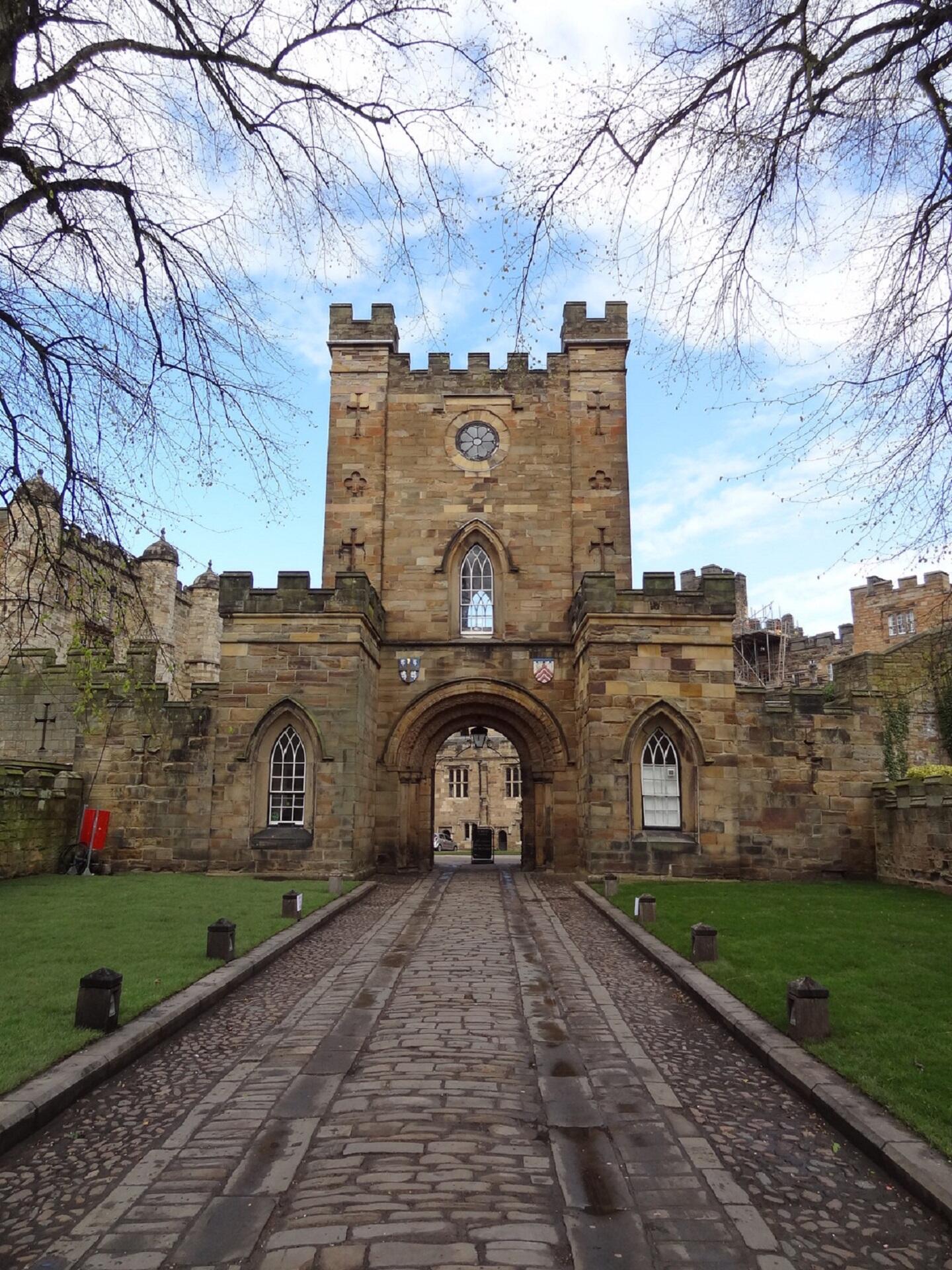 A large stone entryway with a road leading through it.