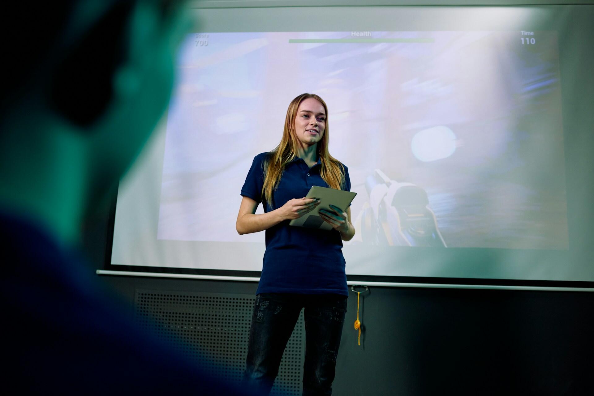 girl presenting in front of a digital board