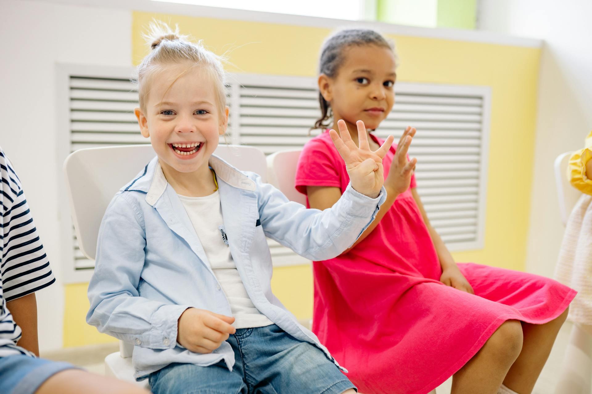 Two children practicing ASL.