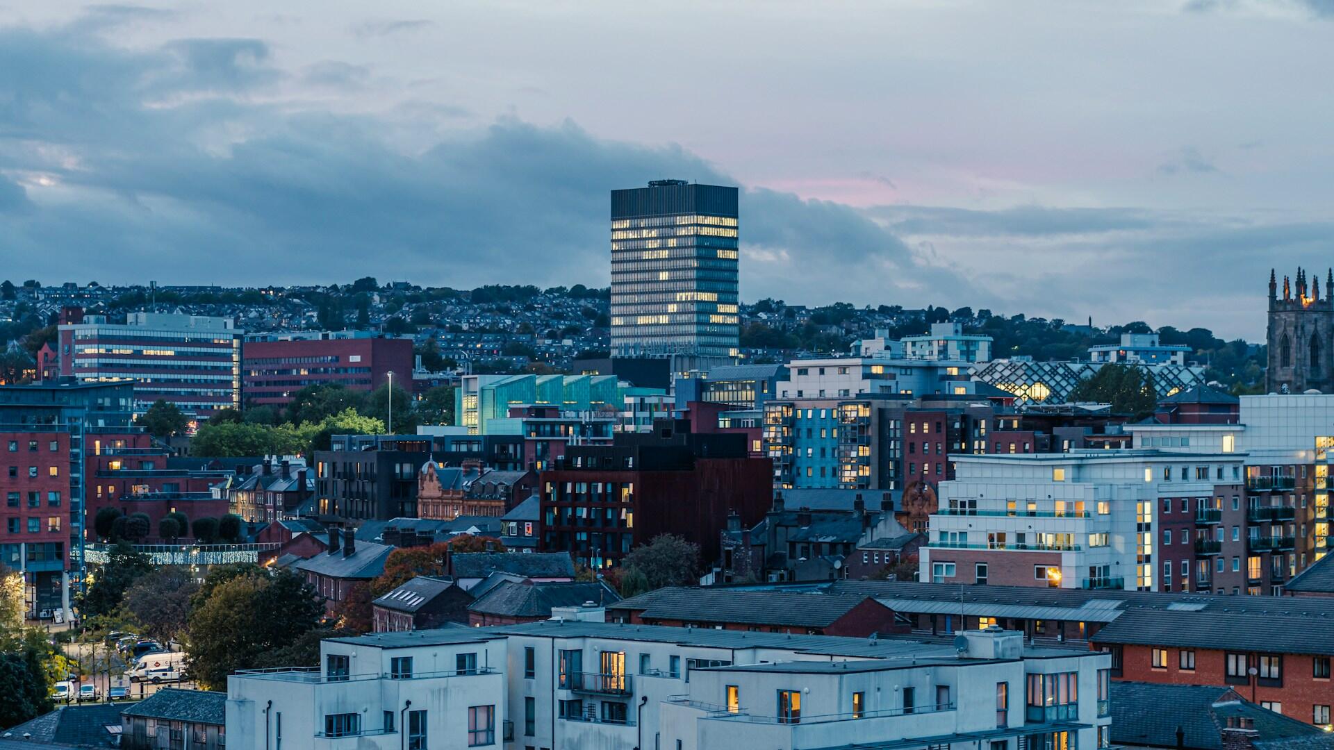 A tall tower above other buildings at dusk.