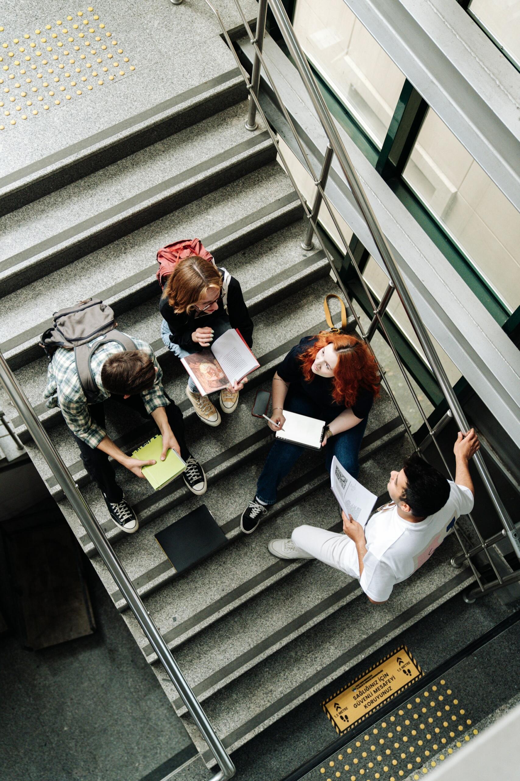 Four students sitting in a stairwell. 