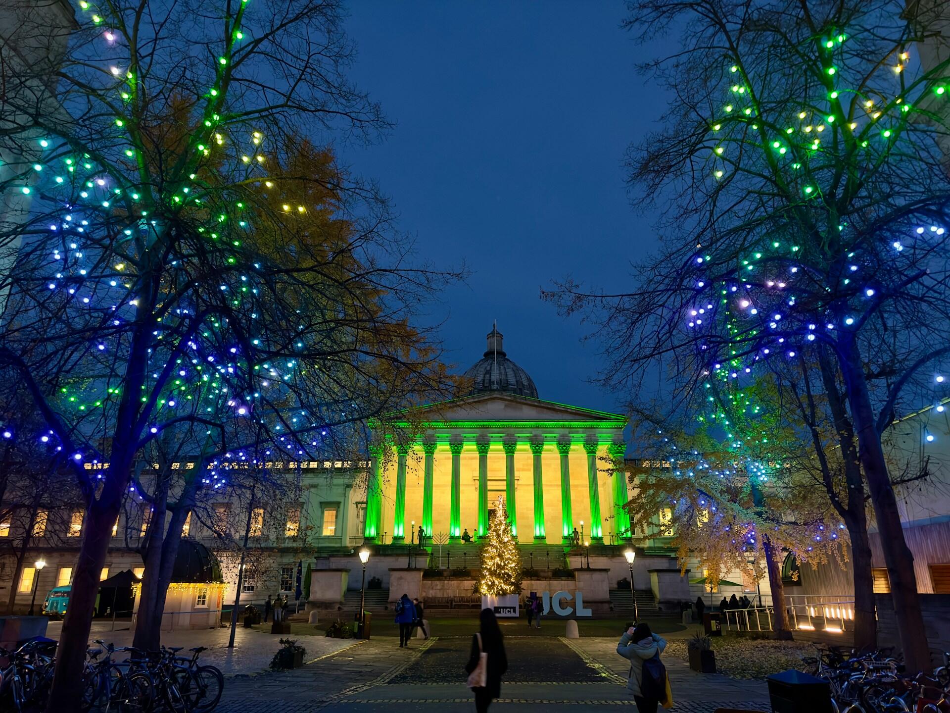 A regal building with columns lit up at night. 