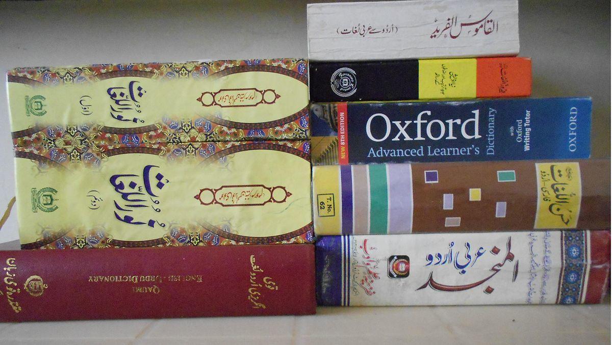 a pile of arabic books as well as an oxford dictionary