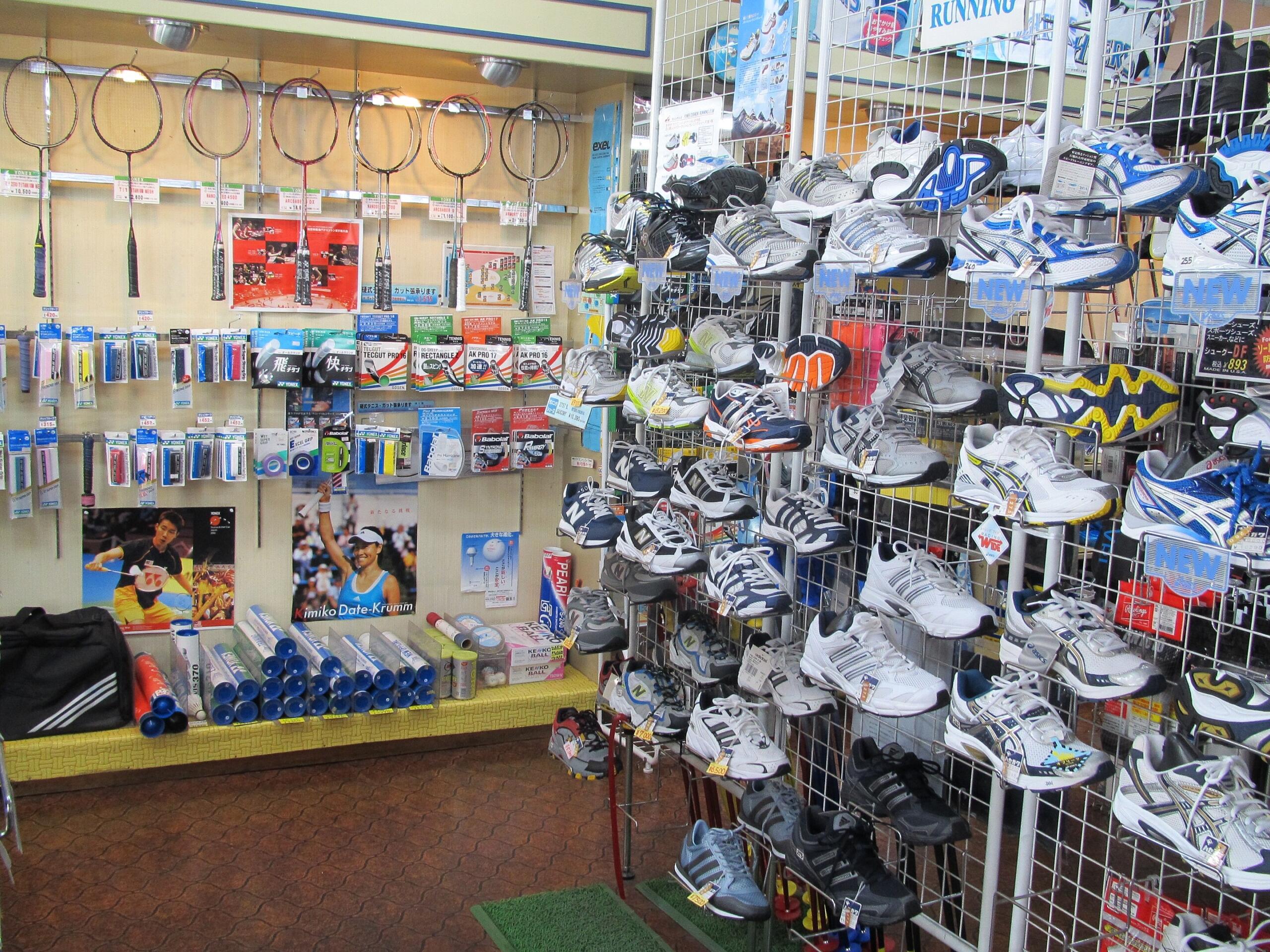 A badminton equipment display featuring shoes, rackets, and accessories. 
