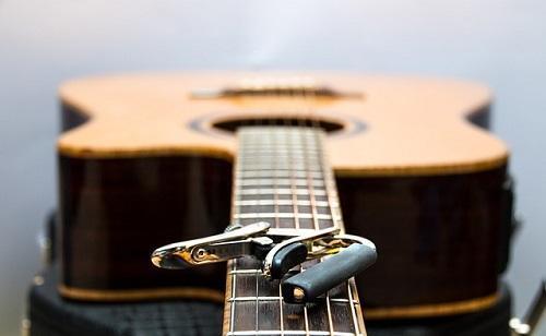 A capo rests on the fretboard of a guitar