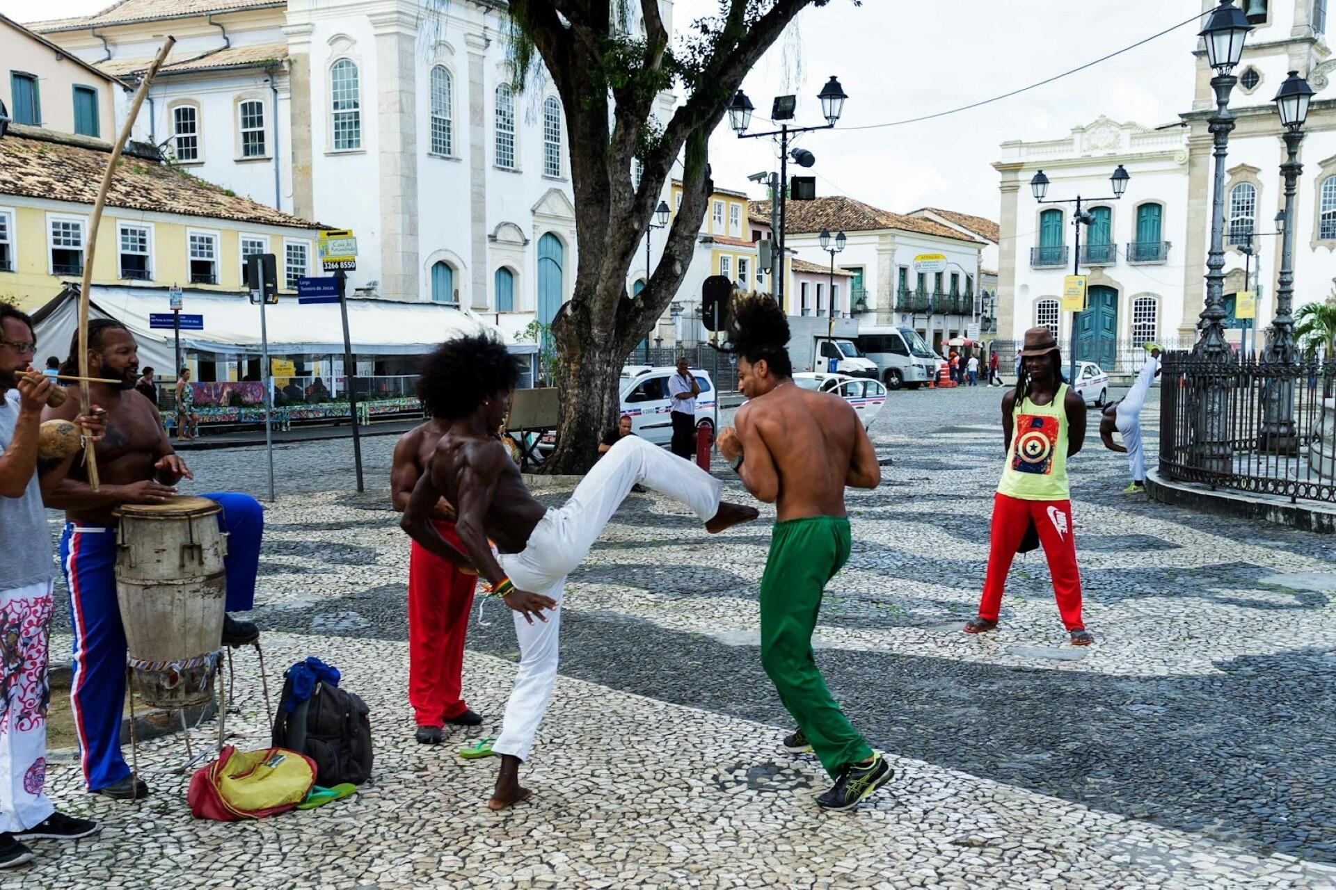 People doing capoeira in the street.