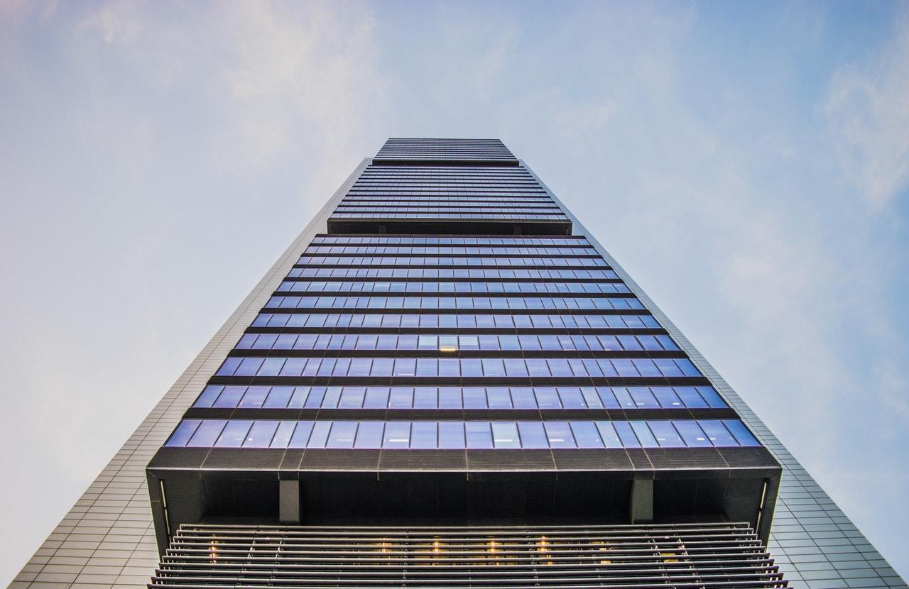 a view looking up from the foot of a skyscraper building